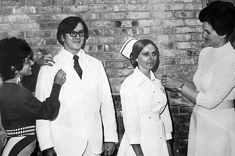 Rose Rivera, far left, and Liz Mathias, far right, congratulating nursing students during a pinning ceremony at Anne Arundel Community College in 1979.