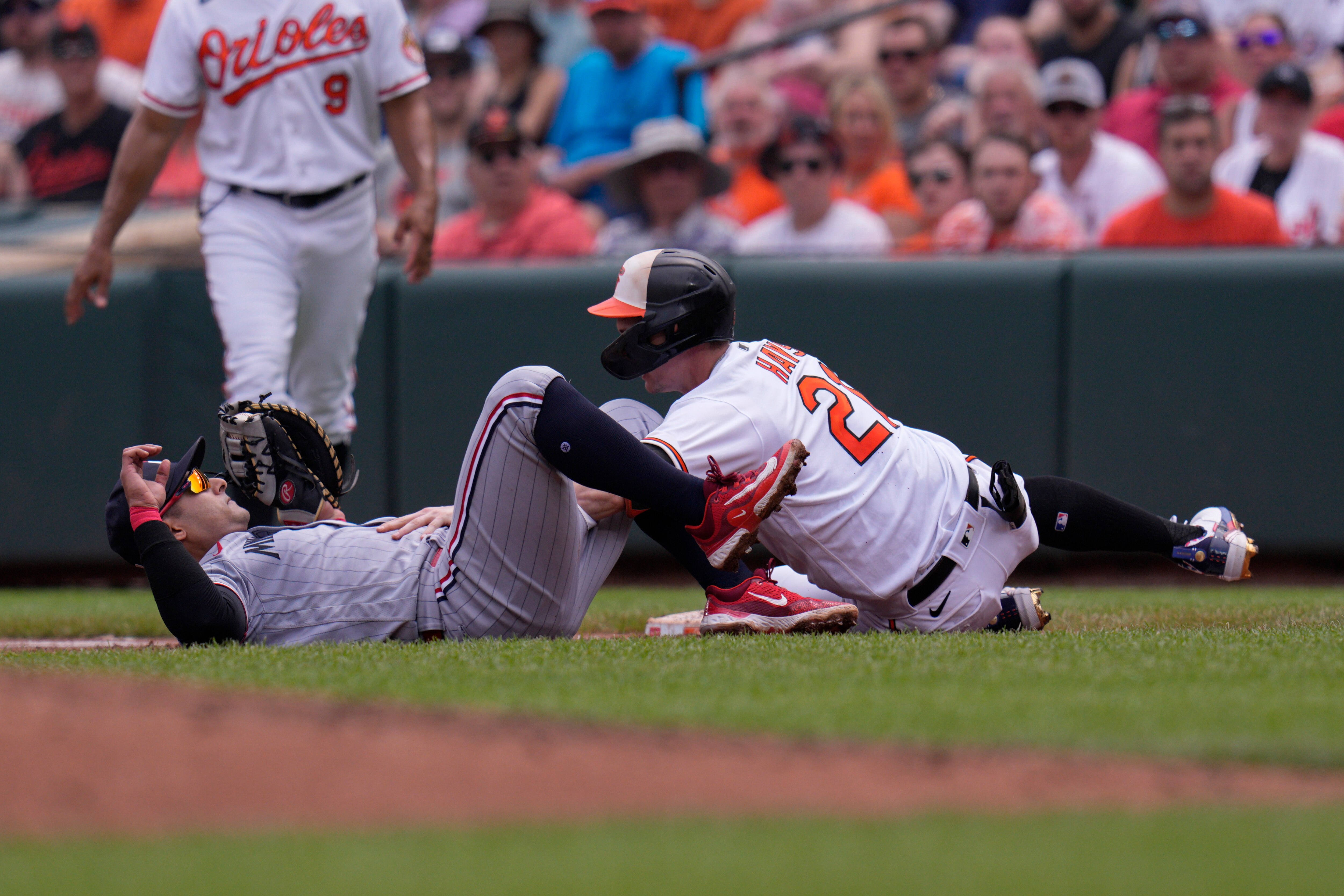 Twins first baseman Donovan Solano (left) and Austin Hays of the Orioles collide during the second inning Sunday at Camden Yards. Hays had to leave the game, which Baltimore won 2-1. Hays is day to day with a left hip injury.