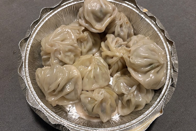 Momo, a signature Nepali dish, come with tangy dipping sauces from the restaurant Butter Chicken in Parkville. You can order chicken, vegetarian, lamb, or ones made from buffalo meat.