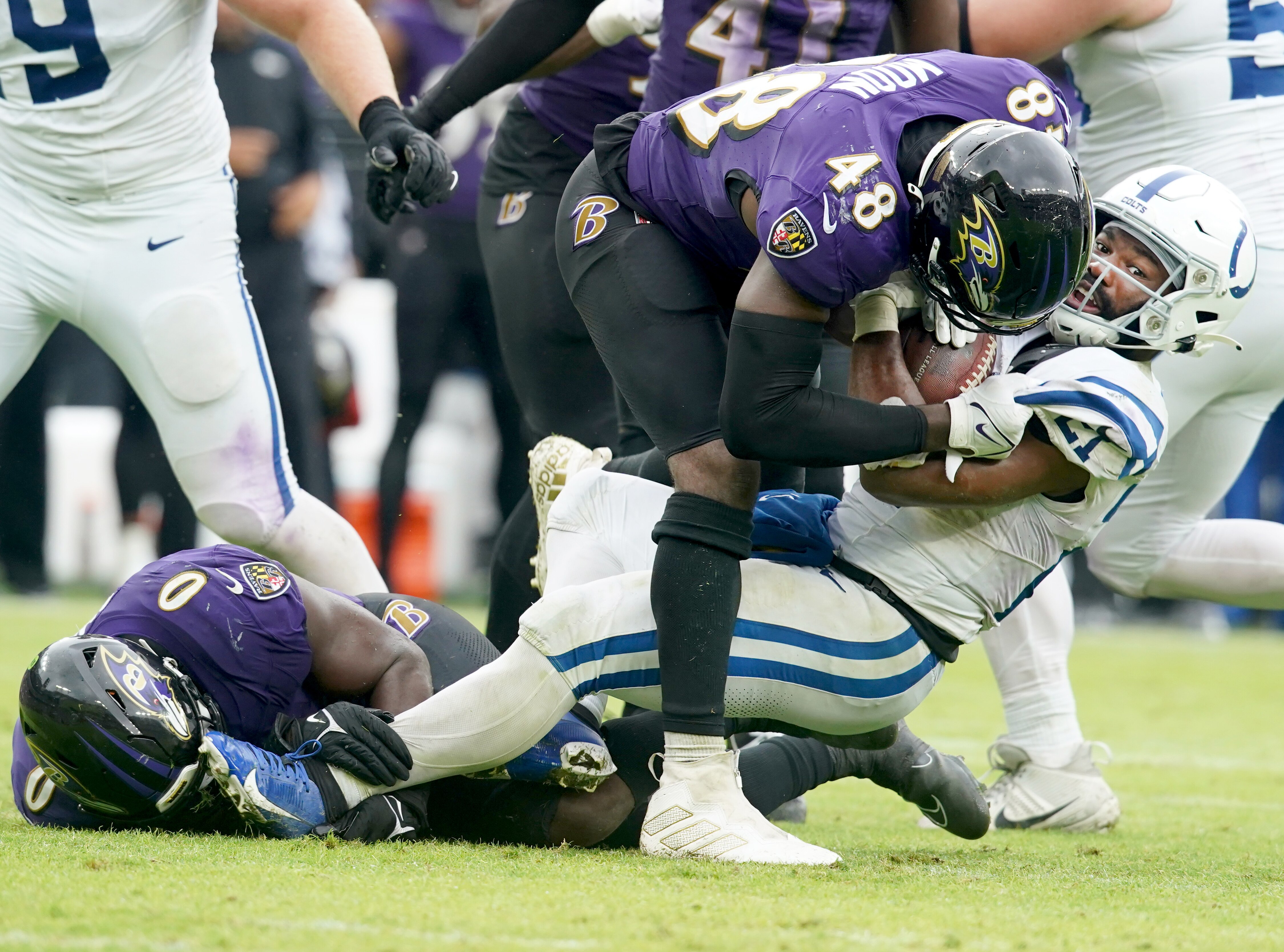 Baltimore Ravens linebacker Roquan Smith (0) and Baltimore Ravens linebacker Jeremiah Moon (48) stop Indianapolis Colts running back Zack Moss (21) for a loss in the backfield during a game against the Indianapolis Colts.