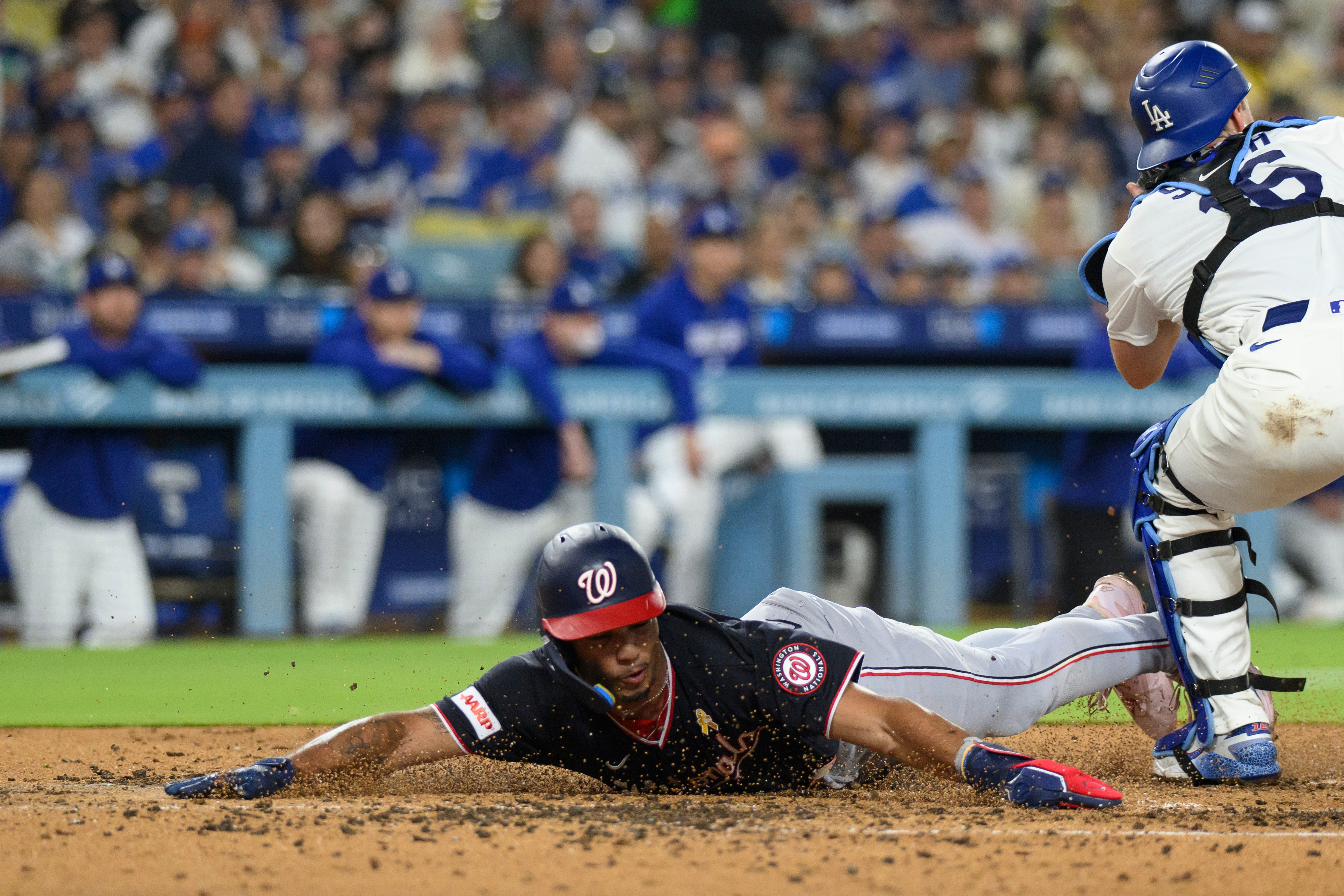 Washington Nationals' Daylen Lile, left, slides to score past Los Angeles Dodgers catcher Will Smith on a two-run double by Harry Ford during the fourth inning of a baseball game in Los Angeles, Sunday, Sept. 6, 2026.