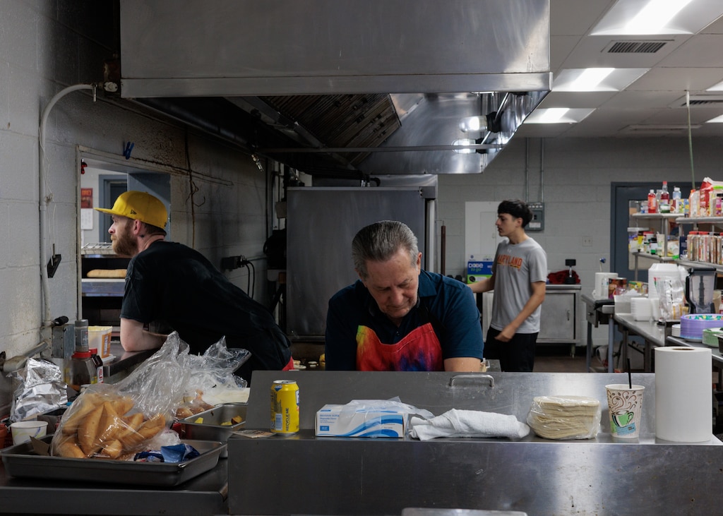 From left, Nolan Byron, Miguel Paz, and John Paz work the kitchen on the stable side of Laurel Park Race Track. John is the 17-year-old grandson of Miguel.