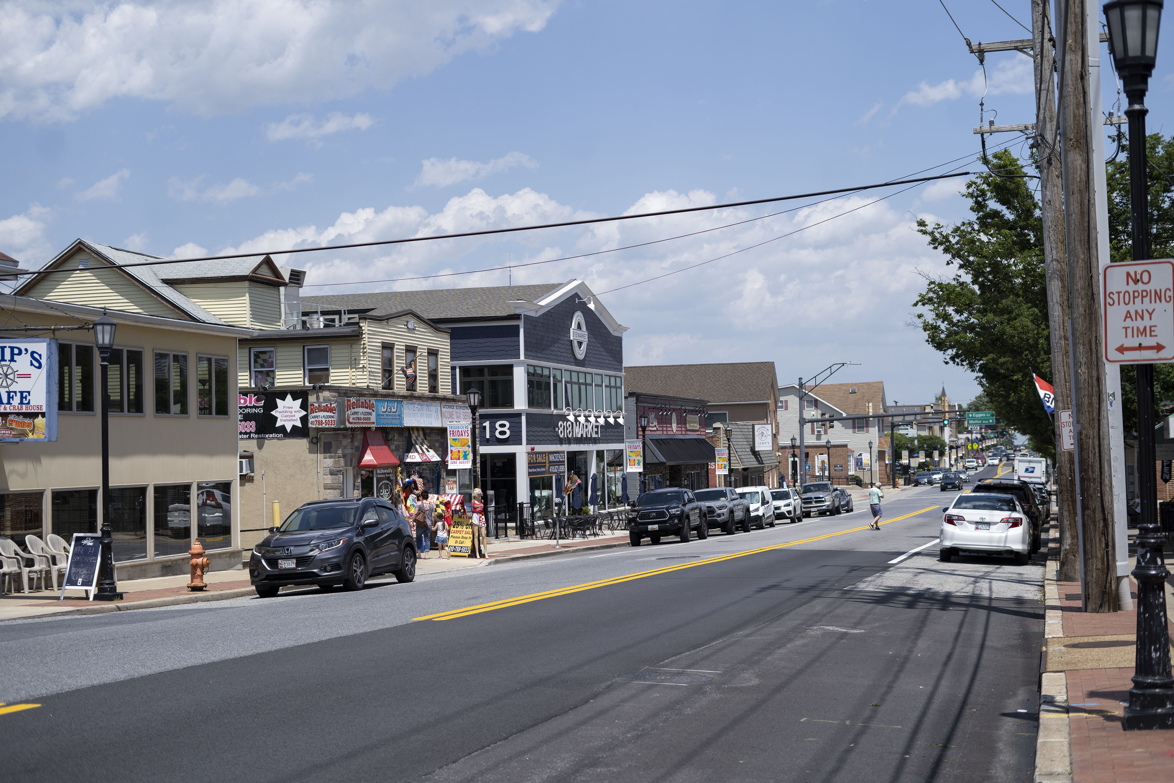 Visitors shop along and walk across Frederick Road in Catonsville, which hosts a weekly farmers market. 