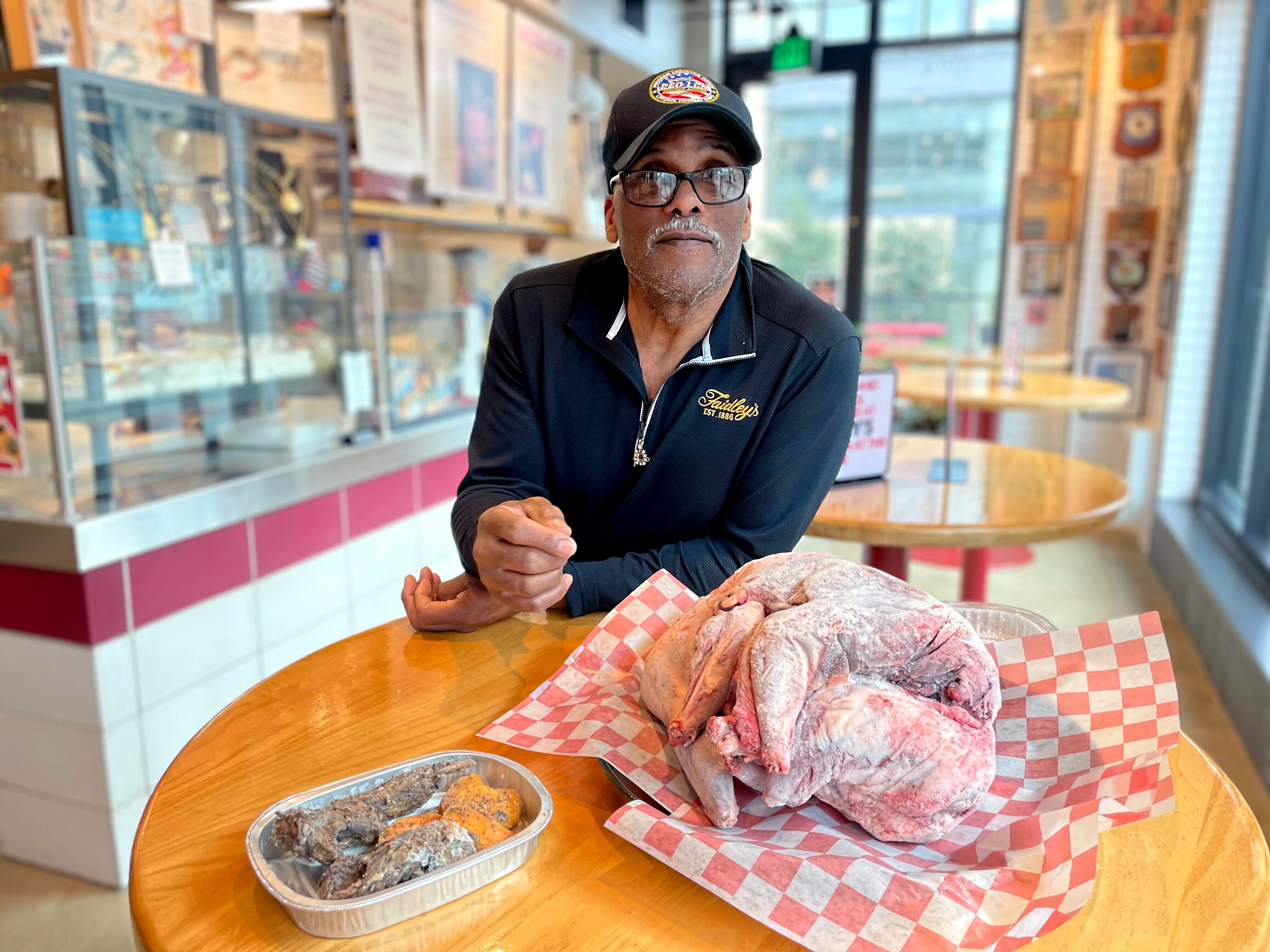 Lou Fleming, general manager of Faidley's Seafood, poses with two frozen raccoon carcasses (right) and a portion of prepared raccoon that he cooked using cayenne pepper, thyme, garlic sauce and salt and pepper. The Lexington Market stand has sold raccoon as well as muskrat since it opened in the 1800s.