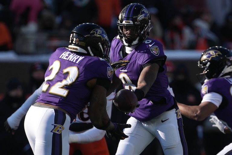 Ravens quarterback Lamar Jackson (8), right, hands the ball off to running back Derrick Henry (22), left, against the Cincinnati Bengals.