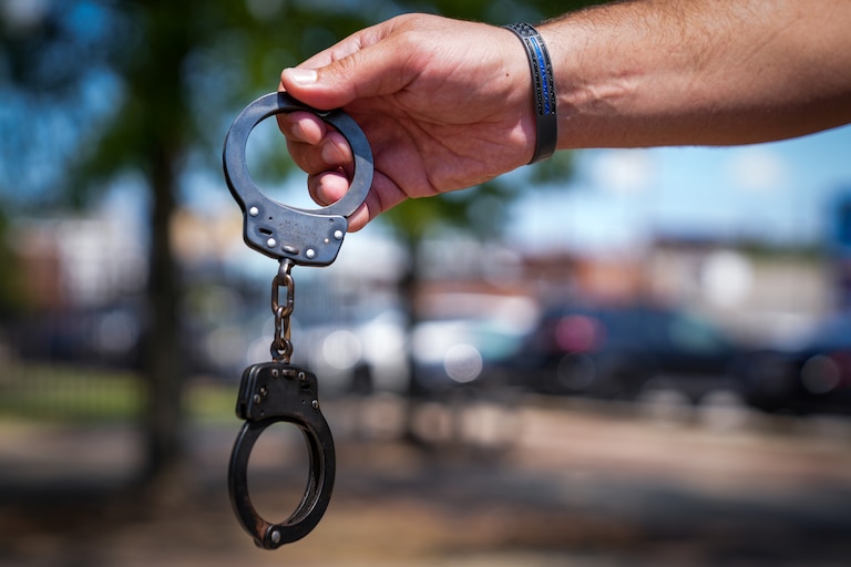 A Baltimore police officer displays his handcuffs on 8/24/22.