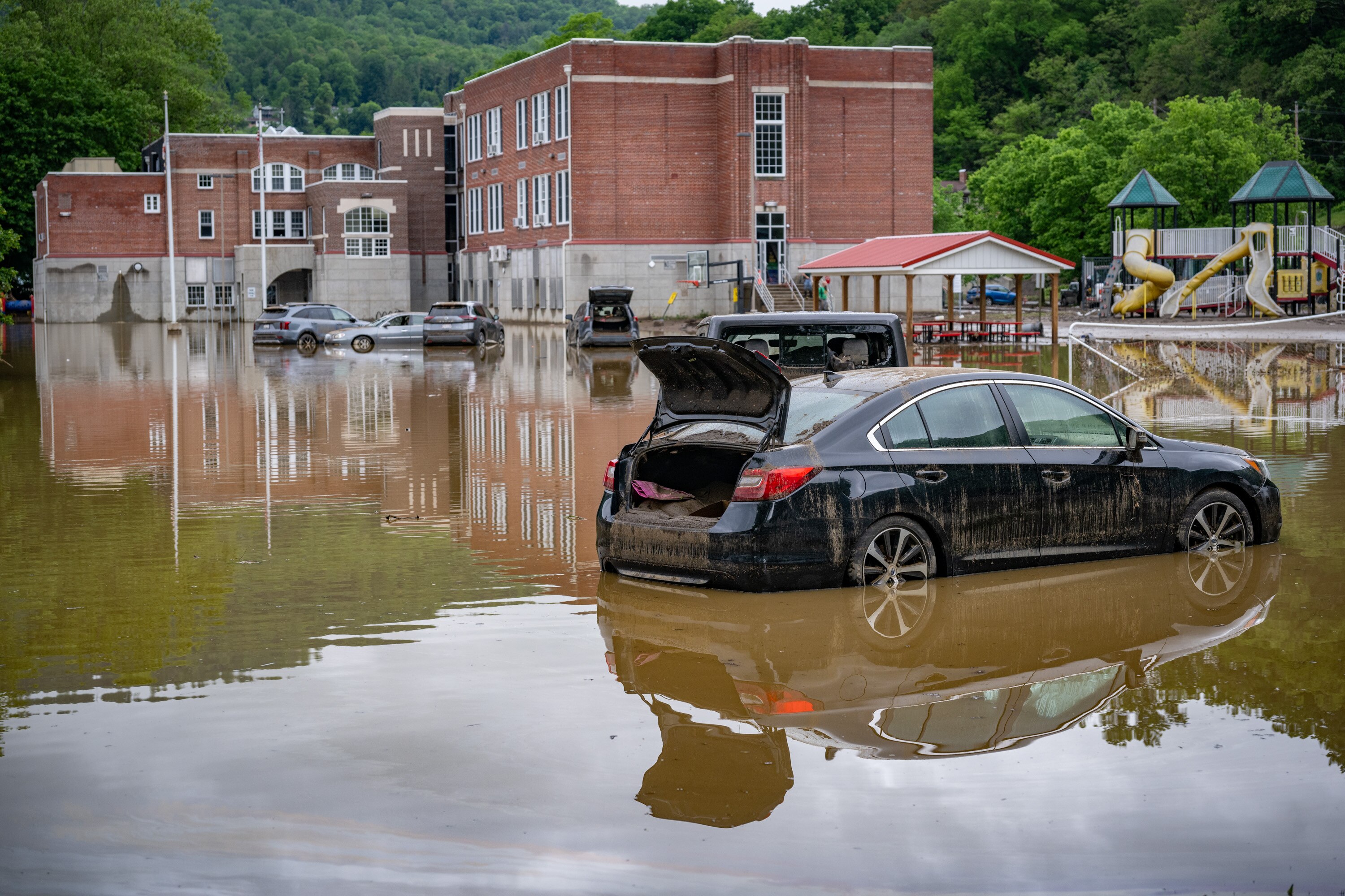 Waterlogged cars sit in the flooded parking lot of Westernport Elementary School after a catastrophic storm hit the area on Tuesday.