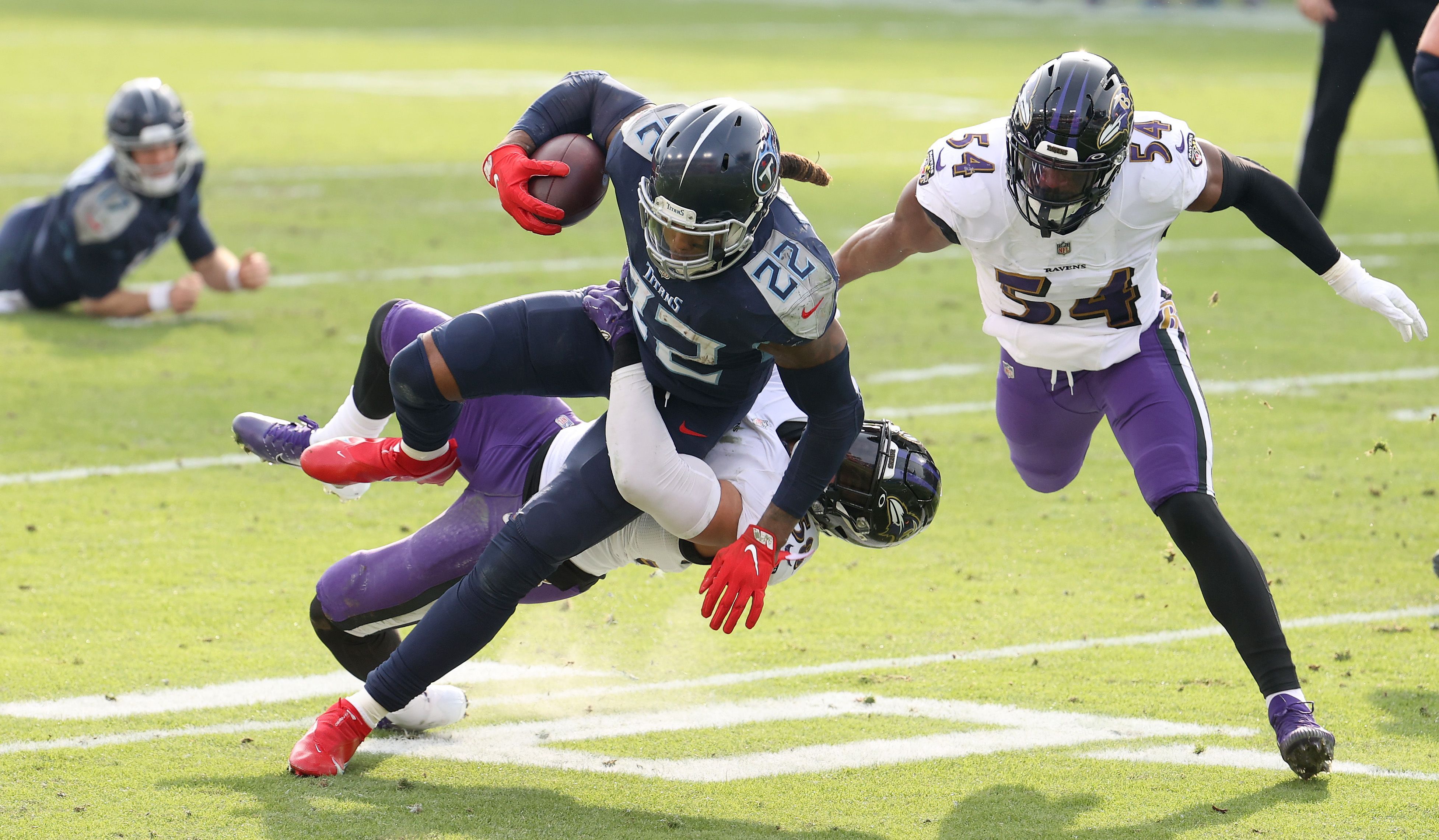Derrick Henry #22 of the Tennessee Titans runs with the ball against the Baltimore Ravens in the Wild Card Round of the NFL Playoffs at Nissan Stadium on January 10, 2021 in Nashville, Tennessee.