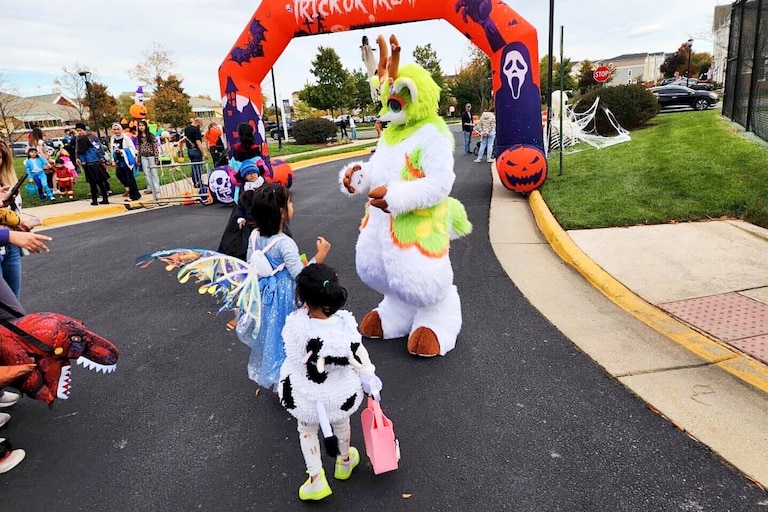 Ash Delmonico portraying Cedar, a green anthropomorphic deer, at a 2024 Northern Virginia Halloween event.