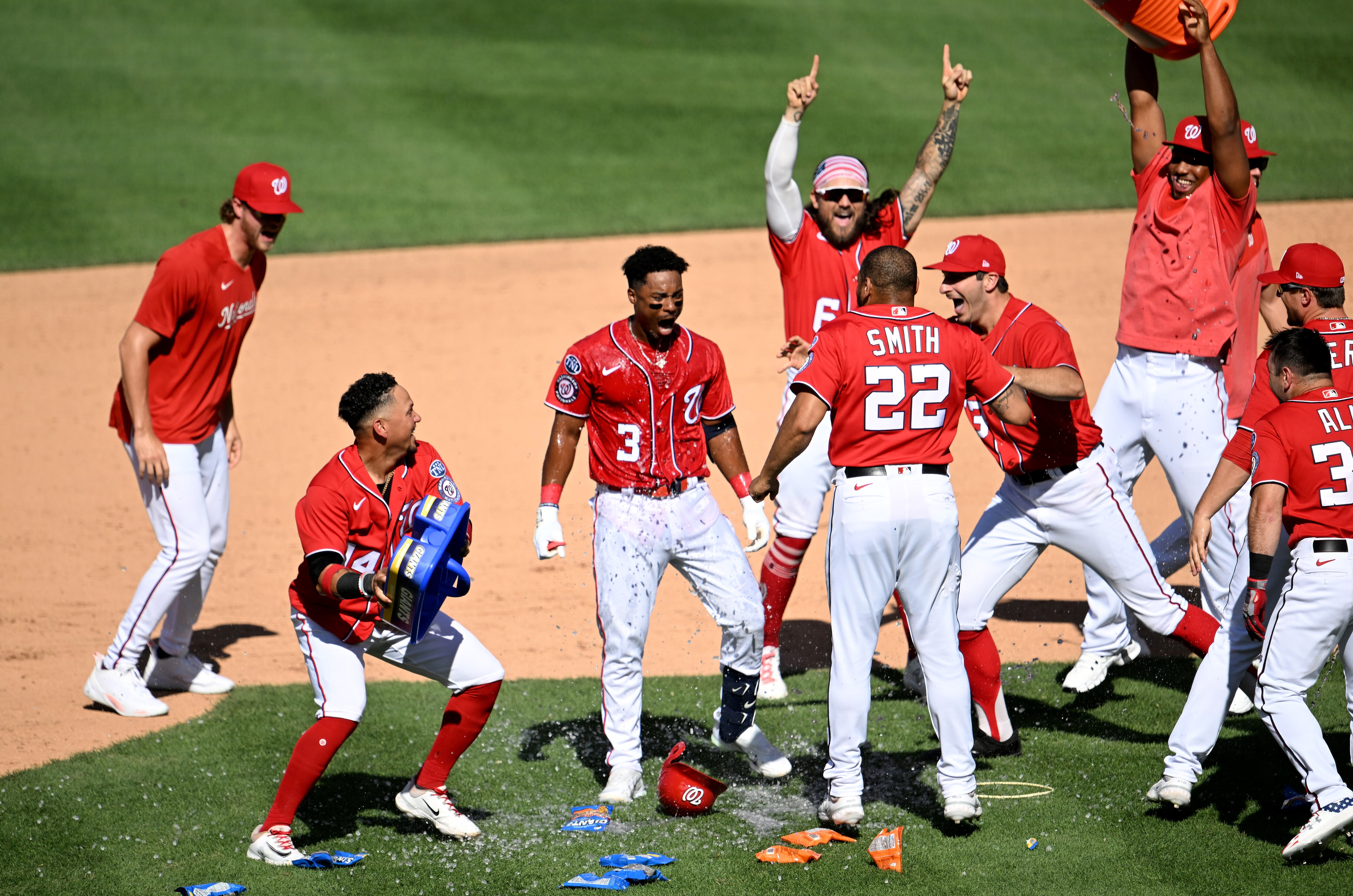 Nationals teammates pounce on Jeter Downs (3) after his game-winning hit Sunday against the Athletics.