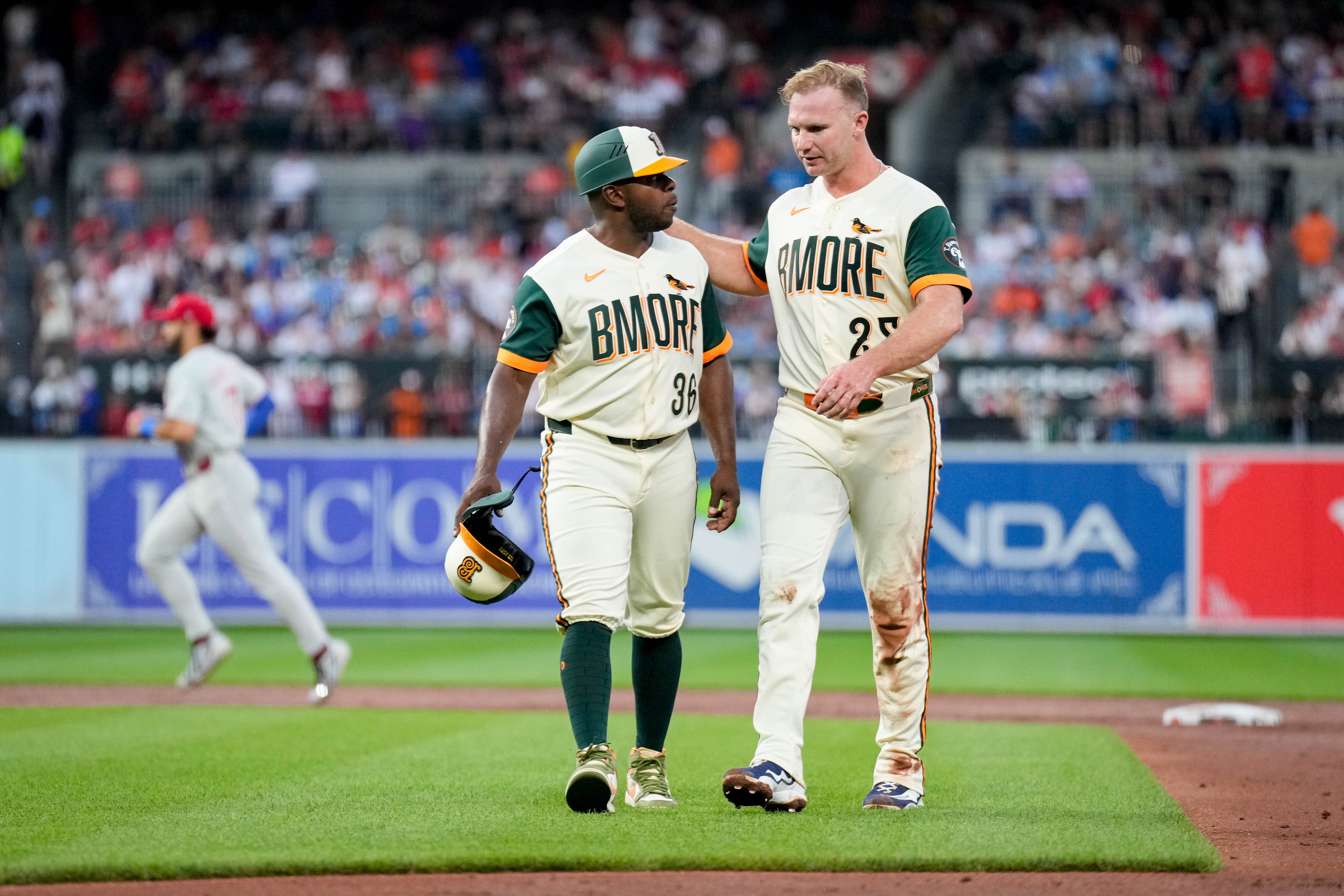 Orioles first base coach Jason Bourgeois (36) and first baseman Pete Alonso (25) confer at the end of the third inning against the Philadelphia Phillies on July 31.