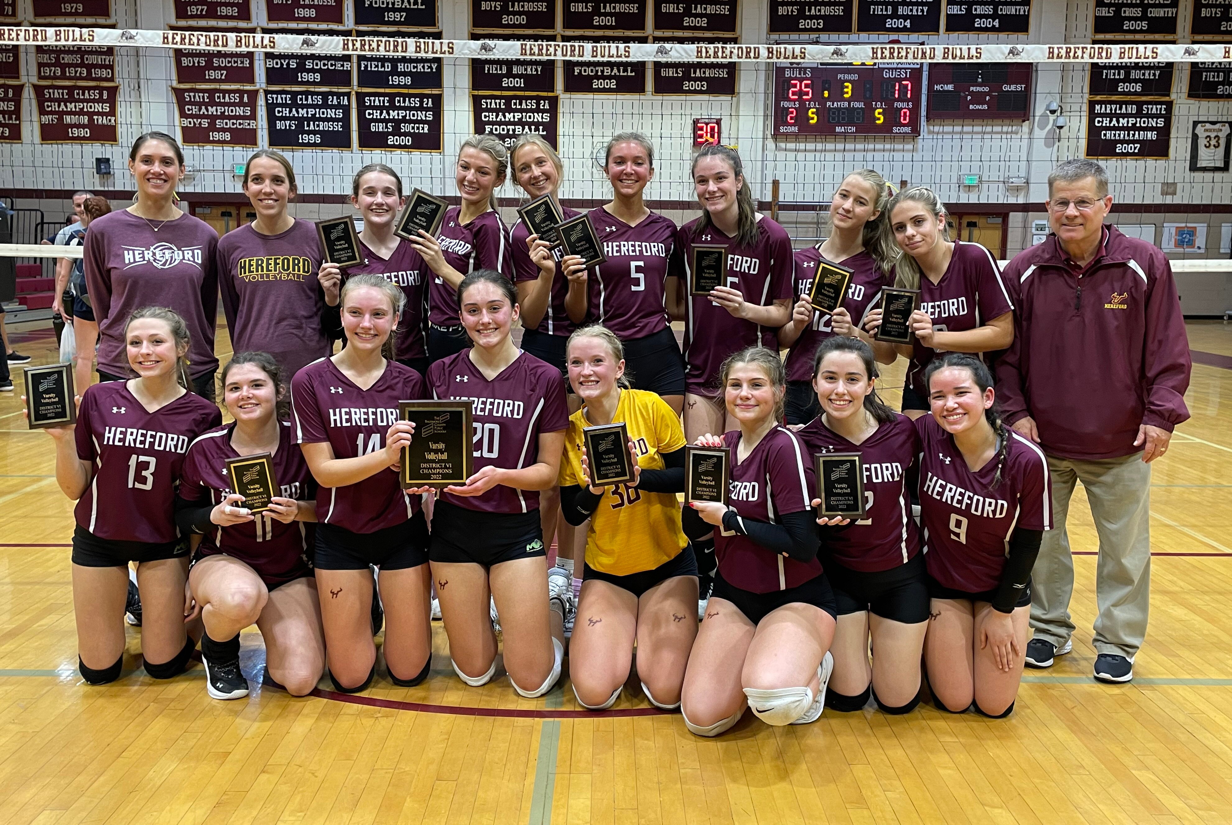 The Hereford volleyball team gathers for a team photo with Baltimore County championship plaques following their three set victory over Perry Hall, Tuesday in Parkton.