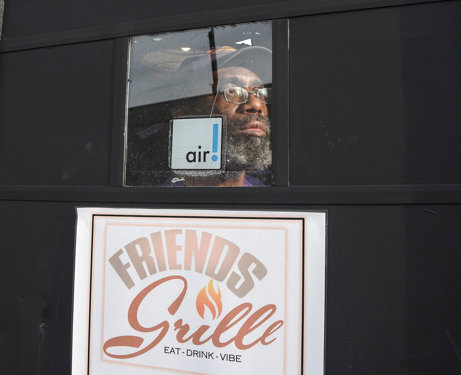 Friends Grille co-owner D. Greene looks out the front door of the Pigtown pub.