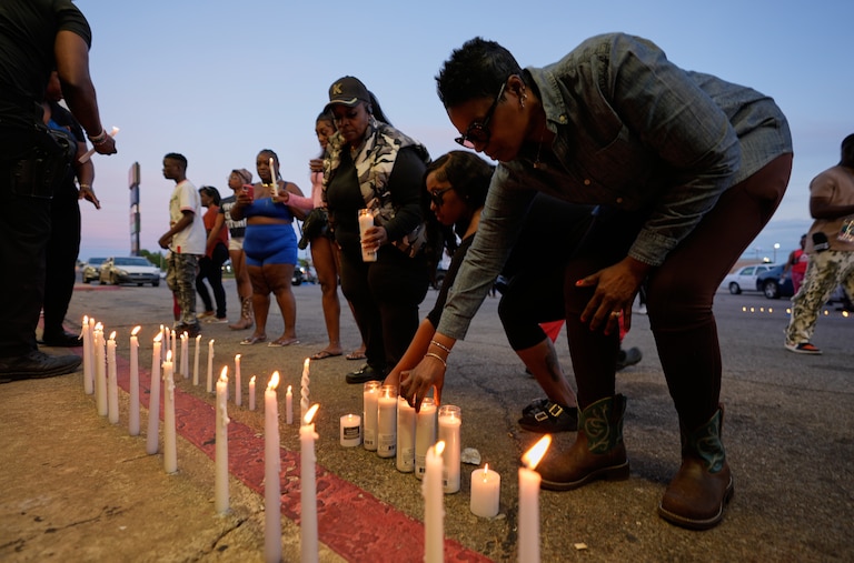 People light candles during a prayer vigil for the victims of a mass shooting earlier in the day, Sunday, April 19, 2026, in Shreveport, La.
