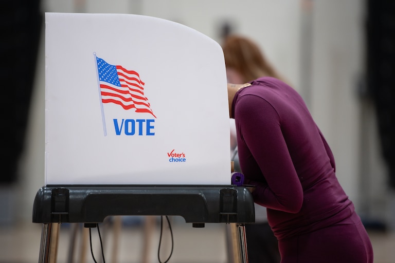A voter leans into their booth while filling out a ballot on Election Day at Oakland Mills High School in Columbia, MD on November 5th, 2024.