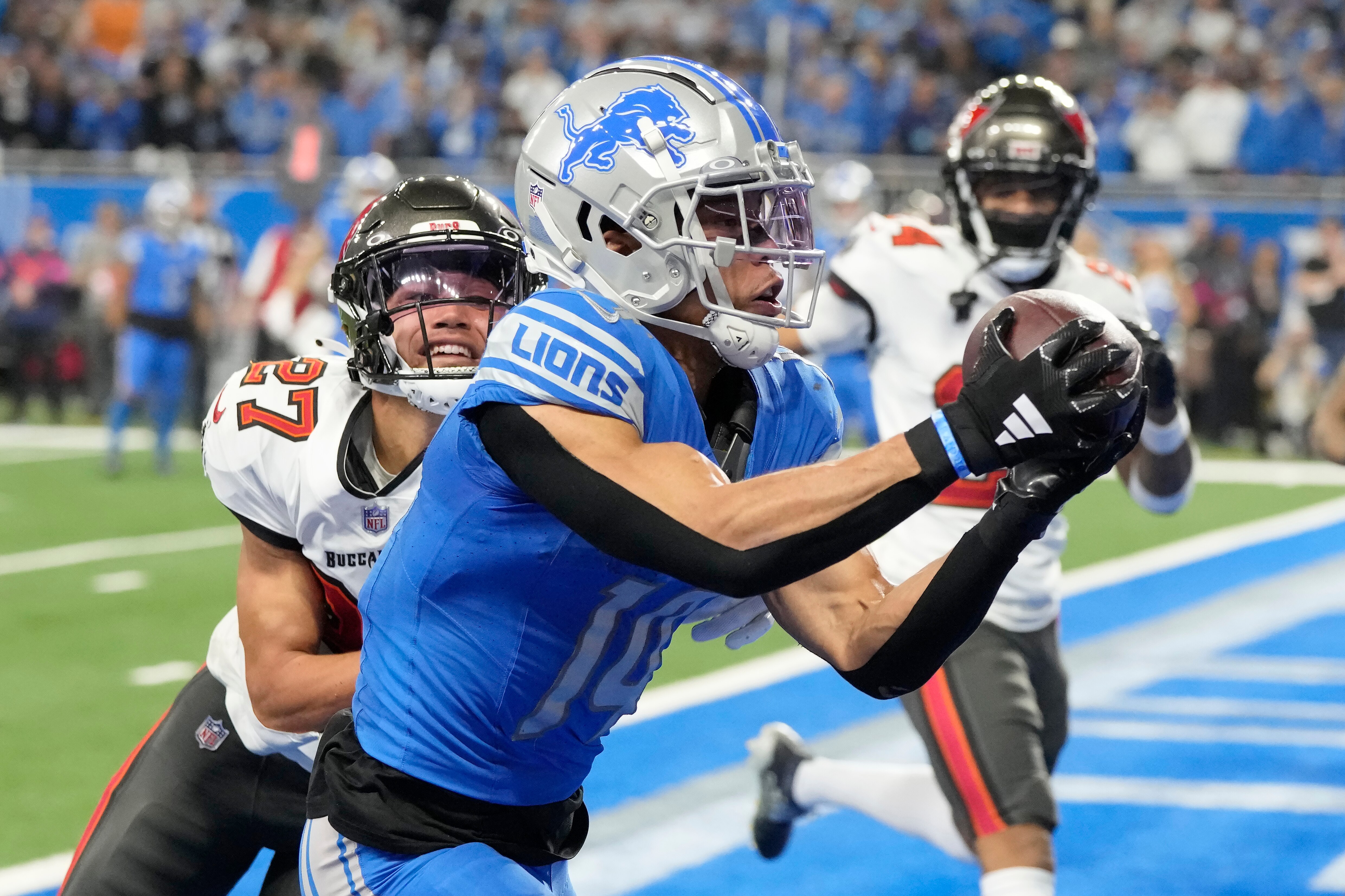 Lions wide receiver Amon-Ra St. Brown catches a touchdown pass in front of Tampa Bay Buccaneers cornerback Zyon McCollum (27) during the second half.