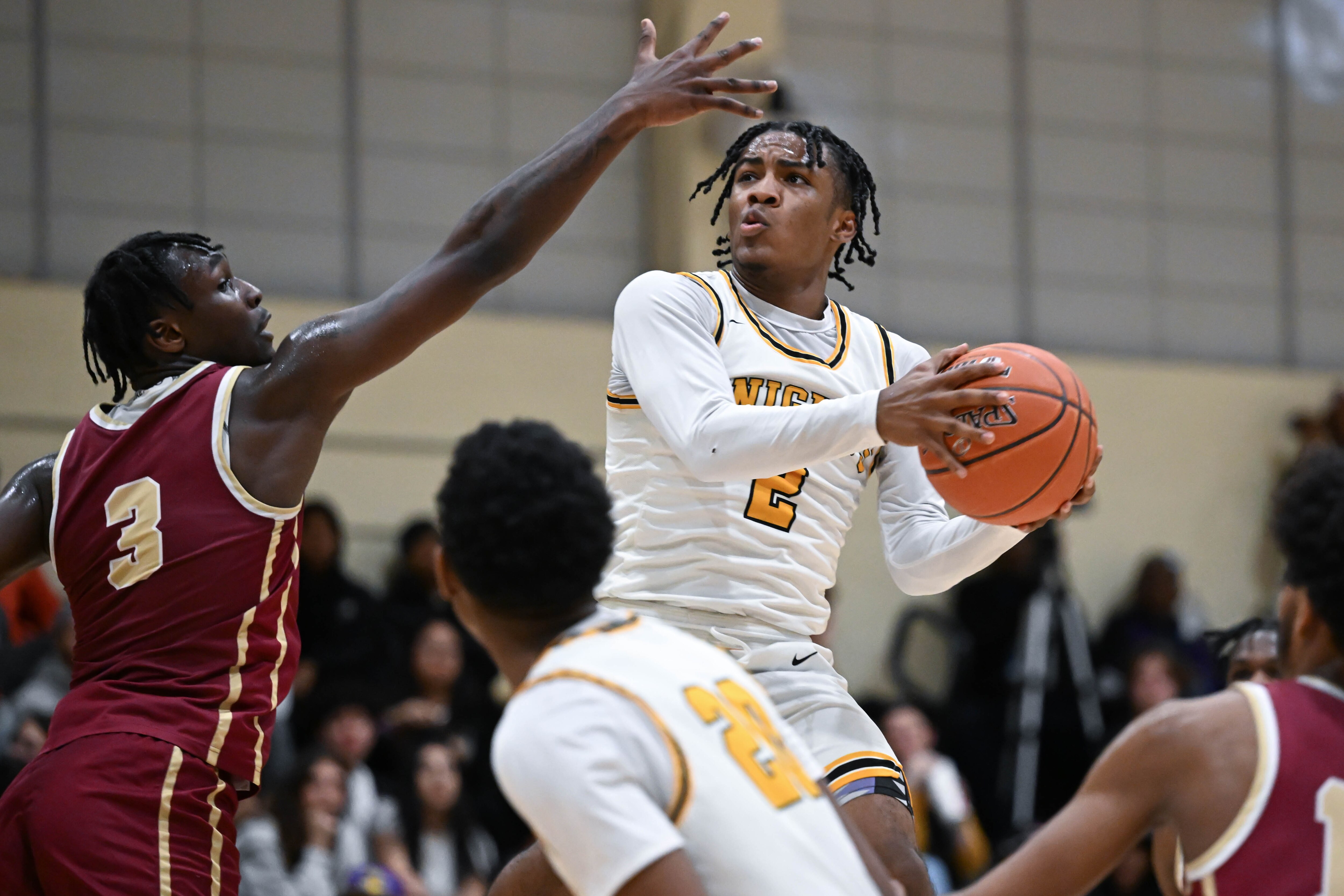 Parkville's Sincere Barfield (2) maneuvers around the defense of New Town's Martaz Robinson (3) during the Knights' 82-74 victory on Friday night.