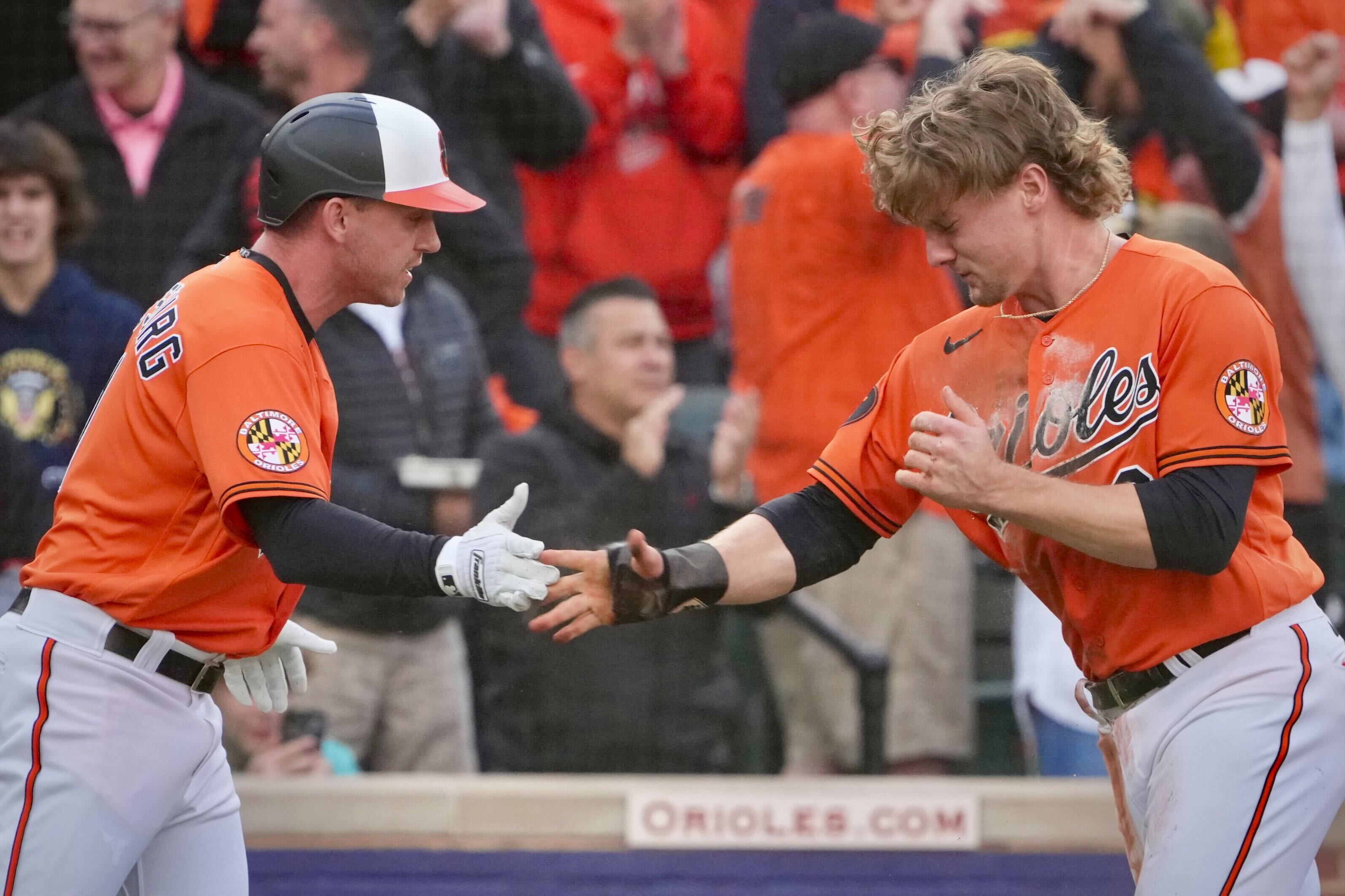 Jordan Westburg and Gunnar Henderson celebrate after scoring a run against the Texas Rangers in Game 2 of the ALDS at Camden Yards.