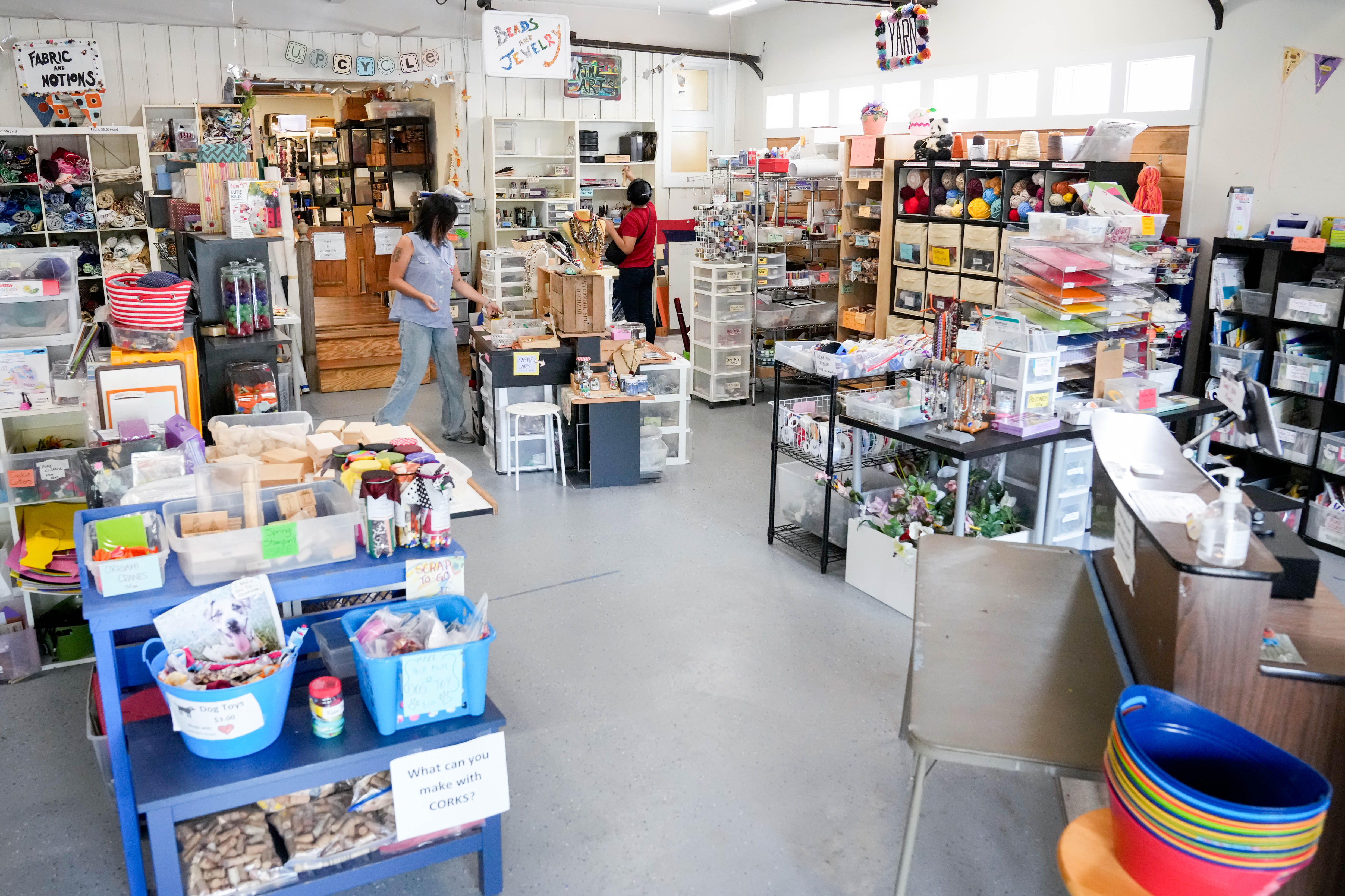 Gabby Rodriguez, center, goes through the stacks of materials available for purchase as store employee Erica Kim, left, organizes crafting goods inside SCRAP Creative Reuse in Pigtown.