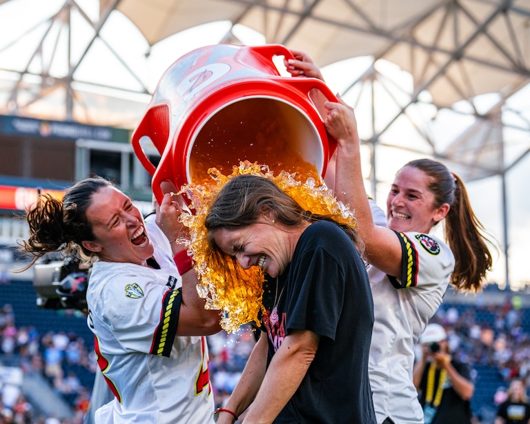 Maryland Charm goalie Caylee Waters and attacker Sam Apuzzo douse head coach Emily Parros with Gatorade