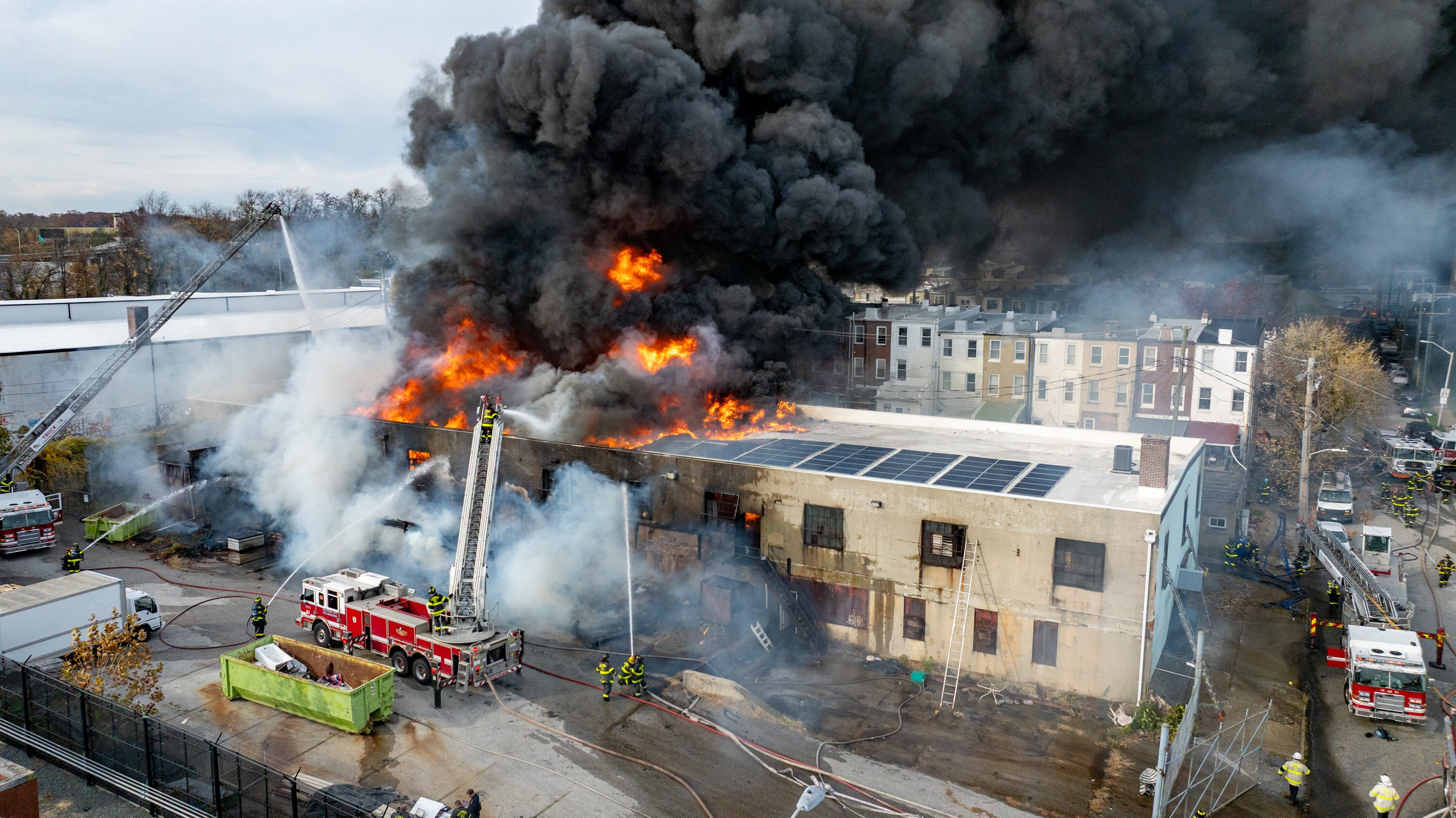 Baltimore Fire crews respond as smoke overtakes a neighborhood from a fire at West 23rd Street and Hampden Avenue in Baltimore on Friday.
