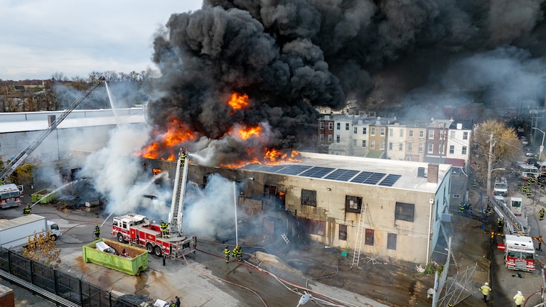 Baltimore Fire crews respond as smoke overtakes a neighborhood from a fire at West 23rd Street and Hampden Avenue in Baltimore on Friday.