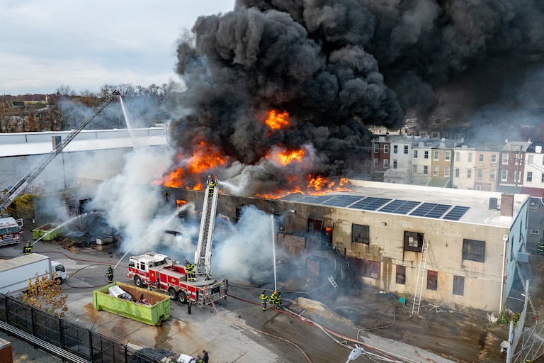 Baltimore Fire crews respond as smoke overtakes a neighborhood from a fire at West 23rd Street and Hampden Avenue in Baltimore on Friday.