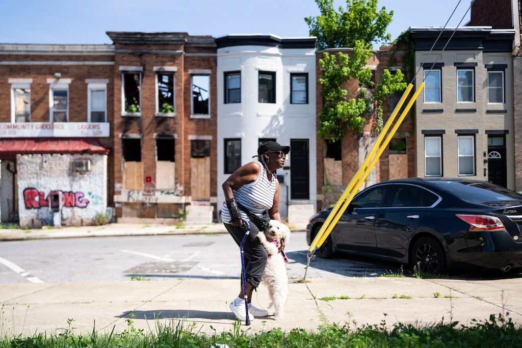 Joan Woodson poses for a portrait with her dog Queen B during their morning walk, in Baltimore, Tuesday, June 30, 2026.