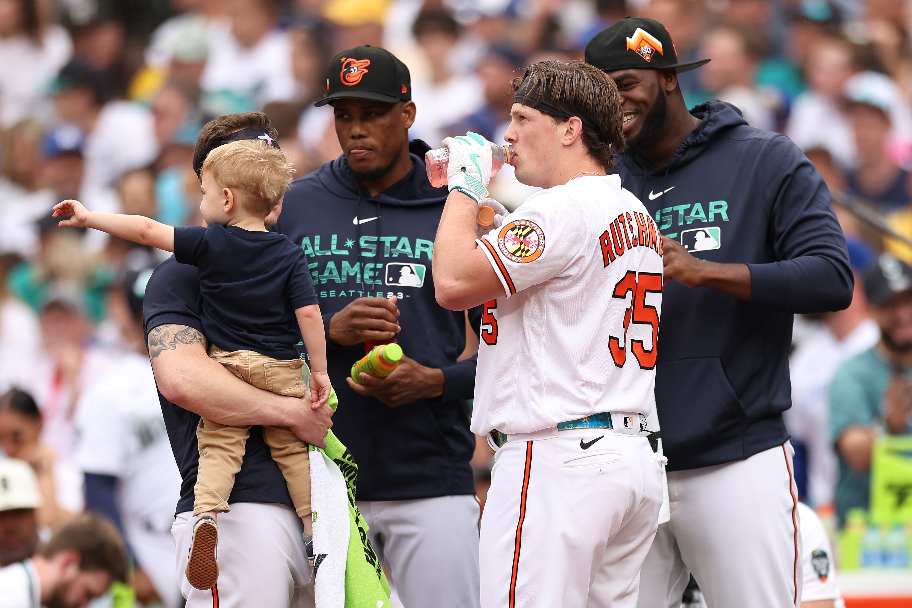 Adley Rutschman, No. 35 of the Baltimore Orioles, meets with teammates during a timeout in the T-Mobile Home Run Derby at T-Mobile Park on July 10, 2023 in Seattle, Washington.