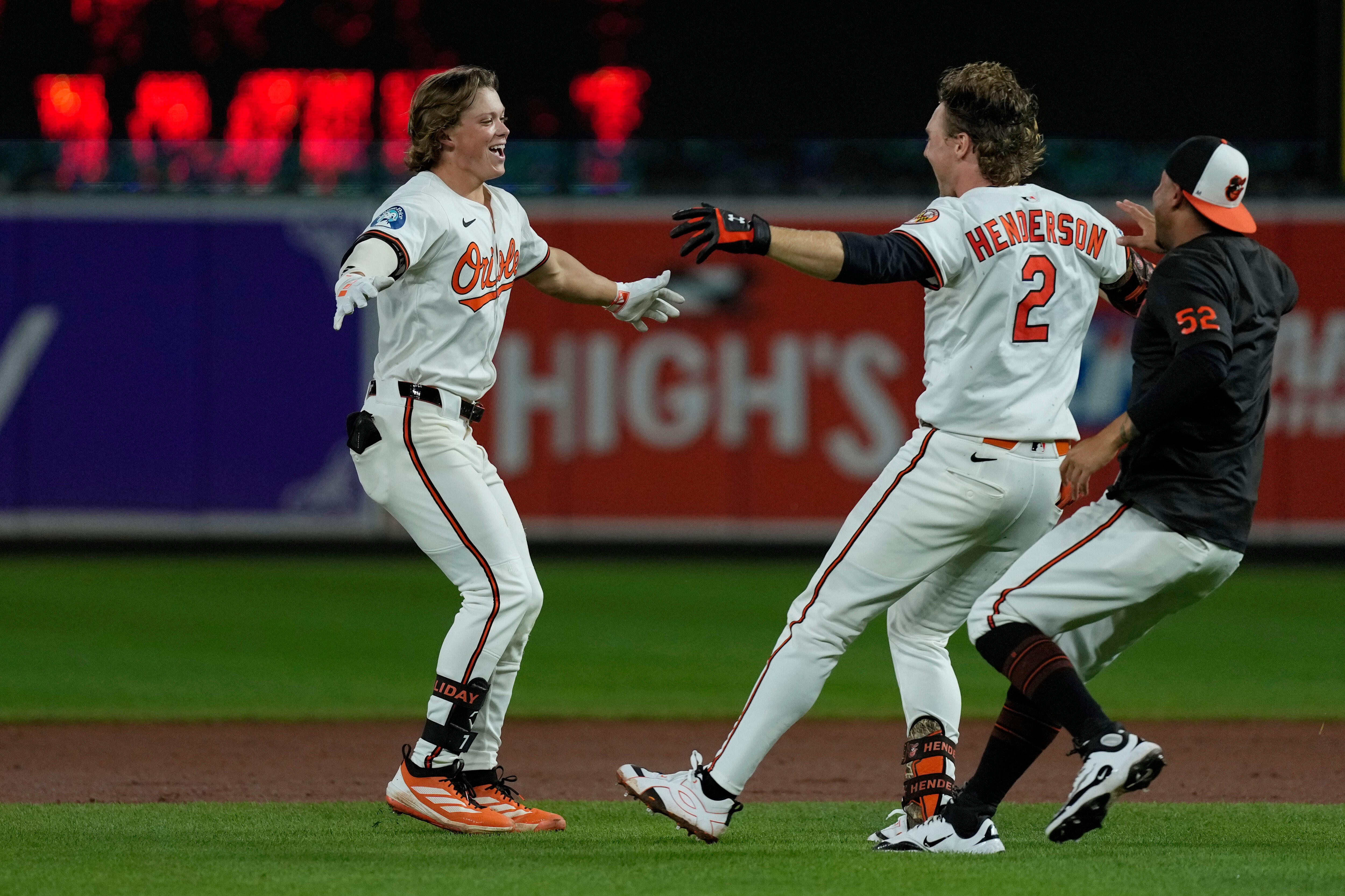 Jackson Holliday celebrates his game-winning double in the ninth inning with Gunnar Henderson and Luis Vázquez on Wednesday night.