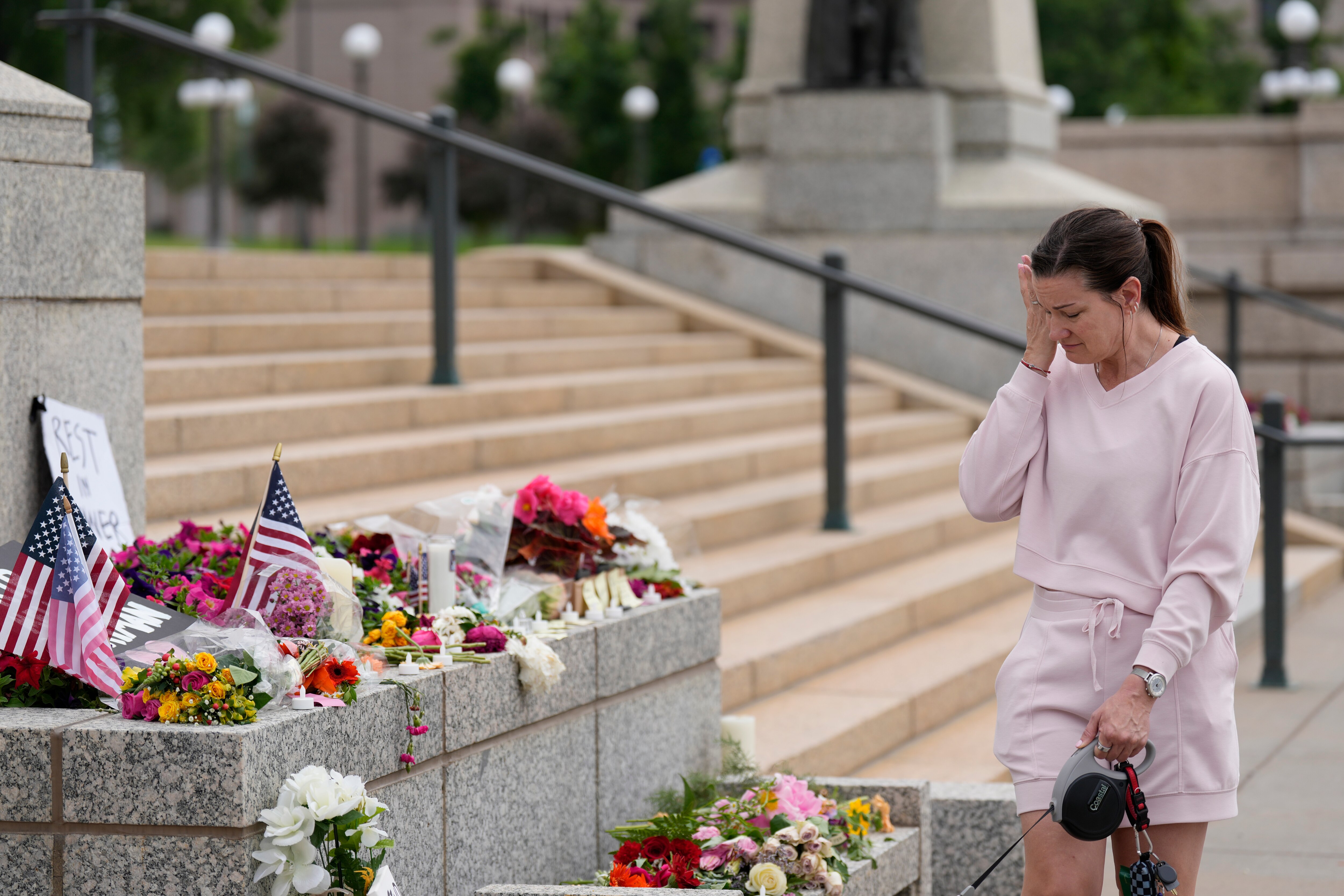 Leah Palmer visits a makeshift memorial for Minnesota state Rep. Melissa Hortman and her husband Mark at the state Capitol, Sunday, June 15, 2025, in St. Paul, Minn. (AP Photo/George Walker IV)