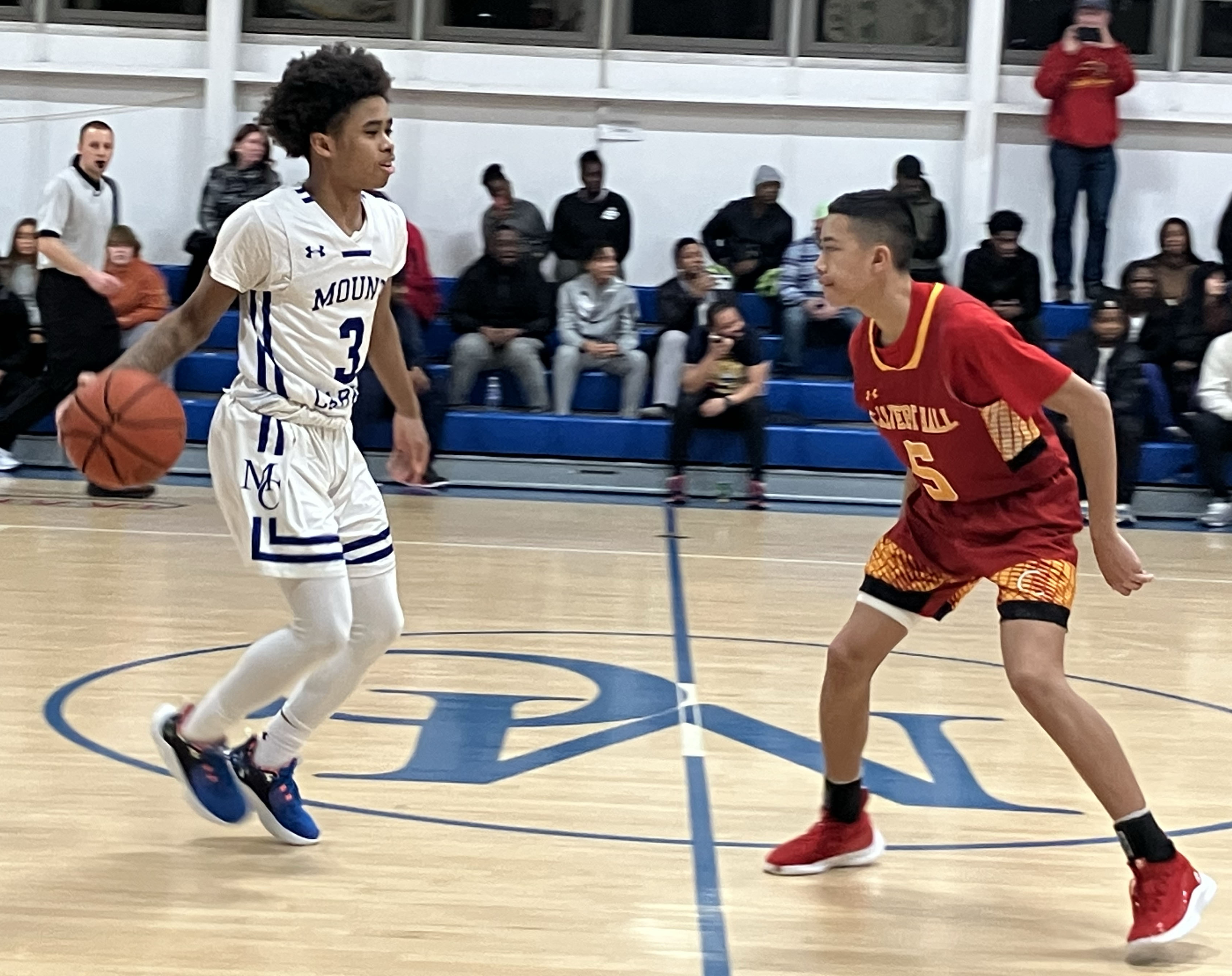 Mount Carmel sophomore guard Rodney Scott brings the ball up the court against Calvert Hall sophomore guard Maclearn Latoga in the No. 5 Cougars’ 67-37 win Tuesday.