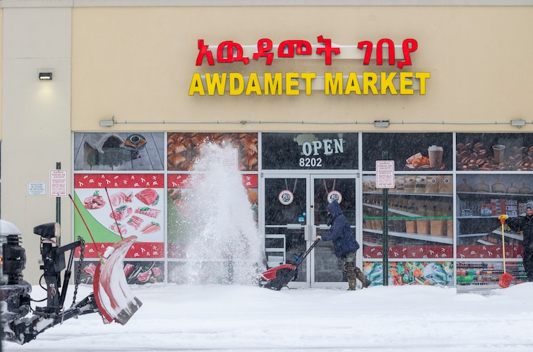 A man operates a snow blower on Sunday, Jan. 25, 2026, during a snowstorm in Silver Spring, Md. in front of Awdamet Market.