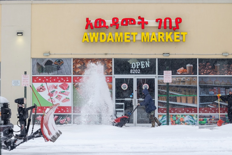 A man operates a snow blower on Sunday, Jan. 25, 2026, during a snowstorm in Silver Spring, Md. in front of Awdamet Market.