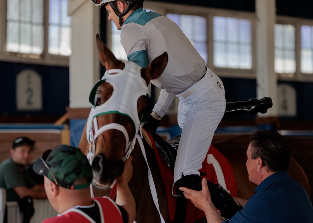 Jockey Sheldon Russell mounts horse Spencer Tiara in the paddock ahead of a race at Laurel Park racetrack.
