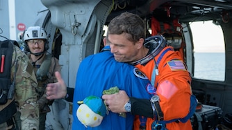 NASA astronaut Reid Wiseman, Artemis II commander, gives NASA Flight Surgeon Richard Scheuring a hug next to a Navy MH-60 Seahawk from Helicopter Sea Combat Squadron (HSC) 23 on the flight deck of USS John P. Murtha after he and fellow crewmates NASA Astronauts Victor Glover, Christina Koch, and CSA (Canadian Space Agency) astronaut Jeremy Hansen, were extracted from their Orion spacecraft after splashdown, Friday, April 10, 2026, in the Pacific Ocean off the coast of California. NASA’s Artemis II mission took the quartet on a nearly 10-day journey around the Moon and back to Earth. Following a splashdown at 5:07 p.m. PDT (8:07 p.m. EDT), NASA, U.S. Navy, and U.S. Air Force teams are working to bring the Orion spacecraft aboard the recovery ship. Photo Credit: (NASA/Bill Ingalls)