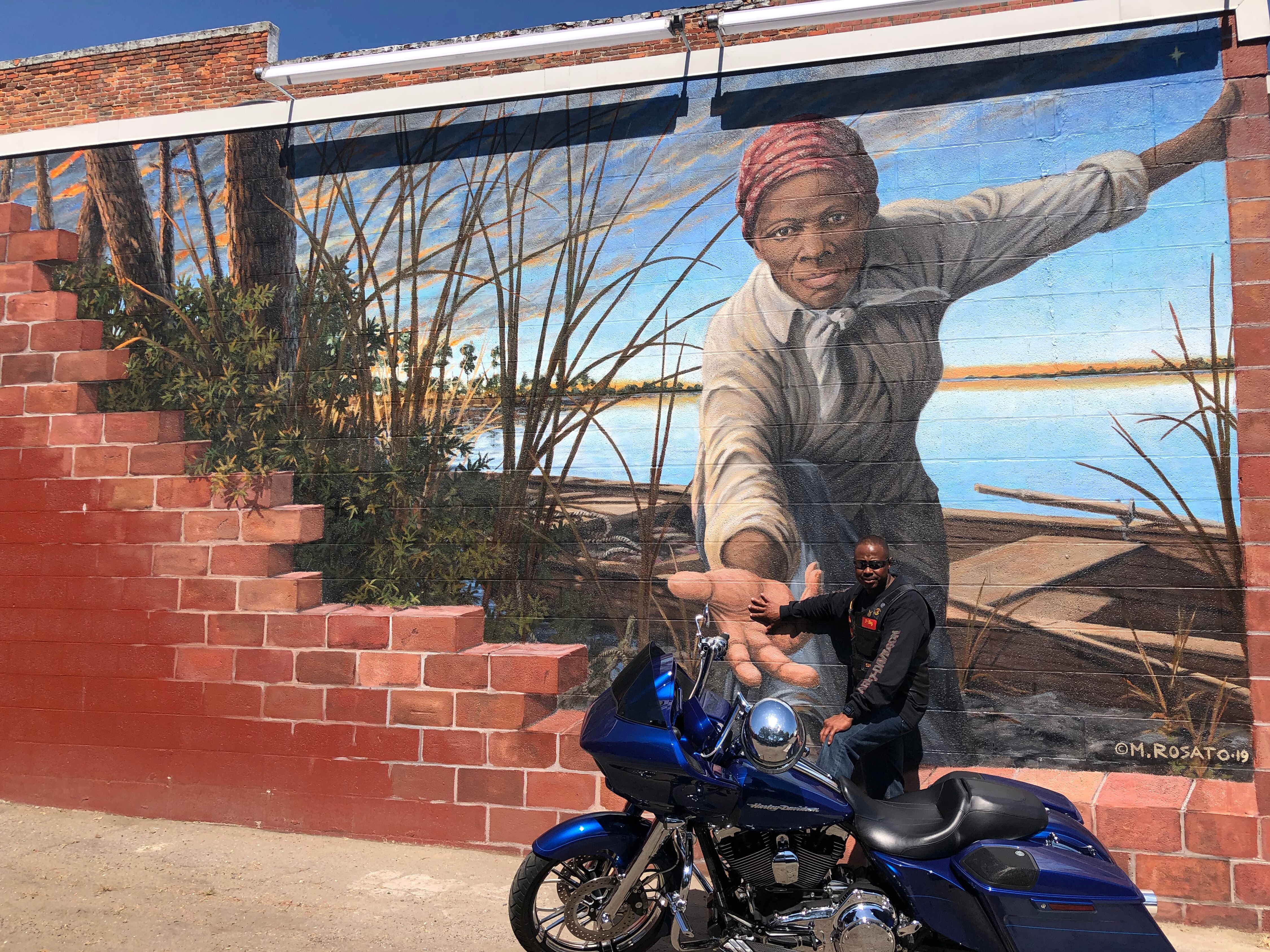 Museummuralbiker: A biker stops by to take Harriet Tubman’s hand.
