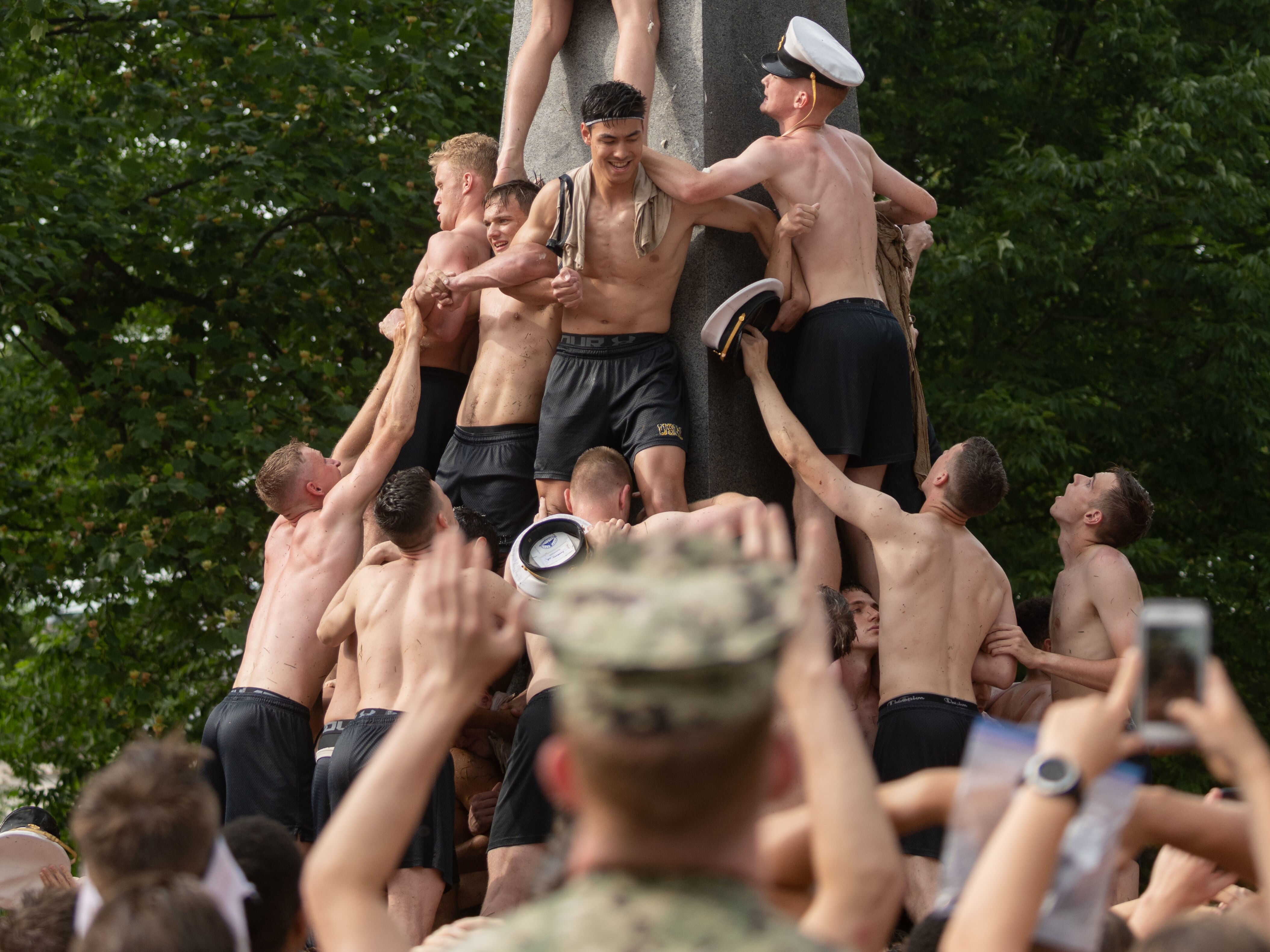 Midshipman 4th Class Michael Lancaster, 19, from Signal Mountain, Tenn., places the midshipman cover atop the Herndon Monument. Naval Academy freshmen, or plebes, climb the granite obelisk in a tradition symbolizing the successful completion of the midshipmen's freshman year.