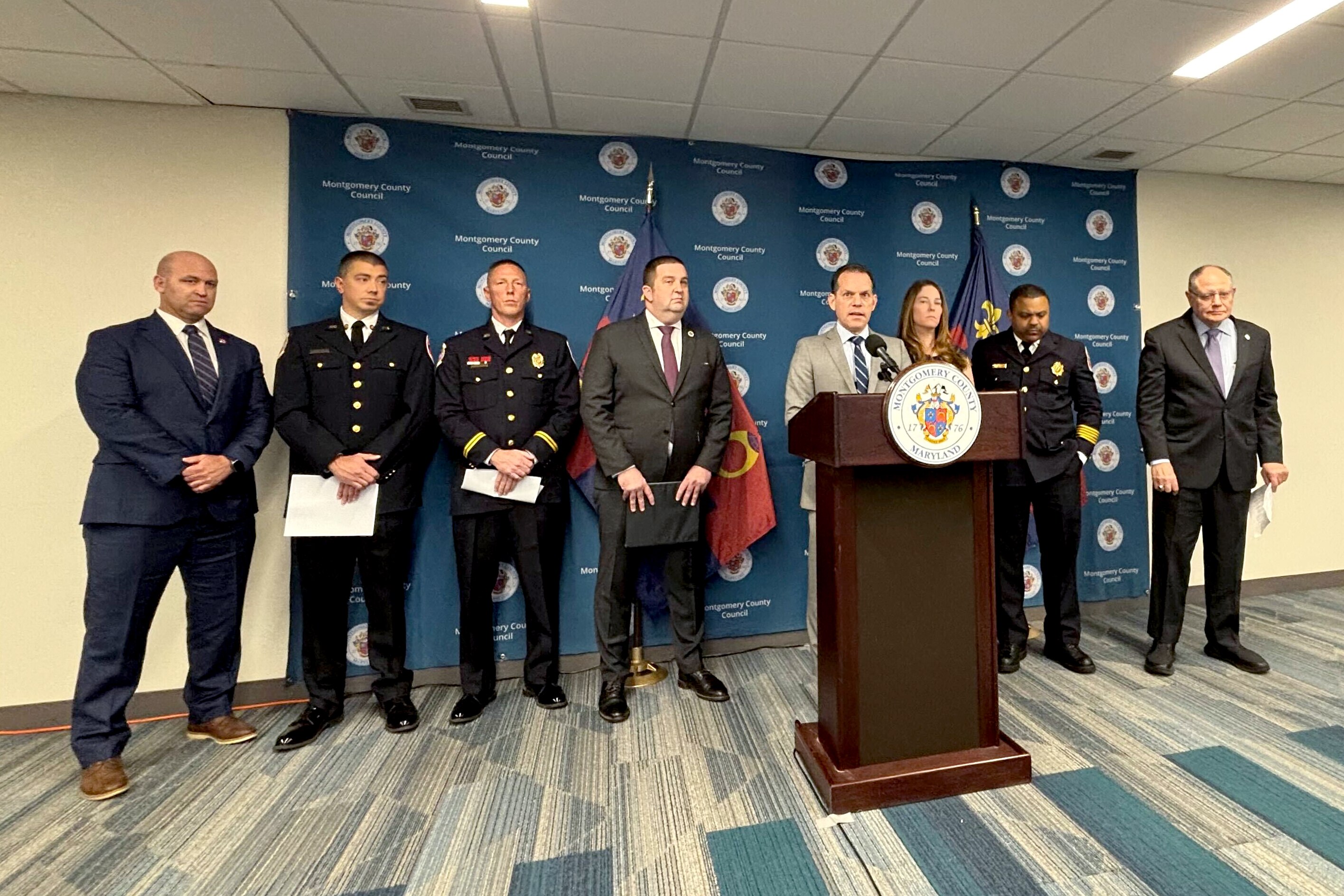 TUESDAY, OCTOBER 21, 2025 - Montgomery County Council member Evan Glass is flanked by supporters of the Hero Act, a bill that would increase pension benefit options for bereaved spouses of first responders, during a press conference in Rockville on Tuesday.