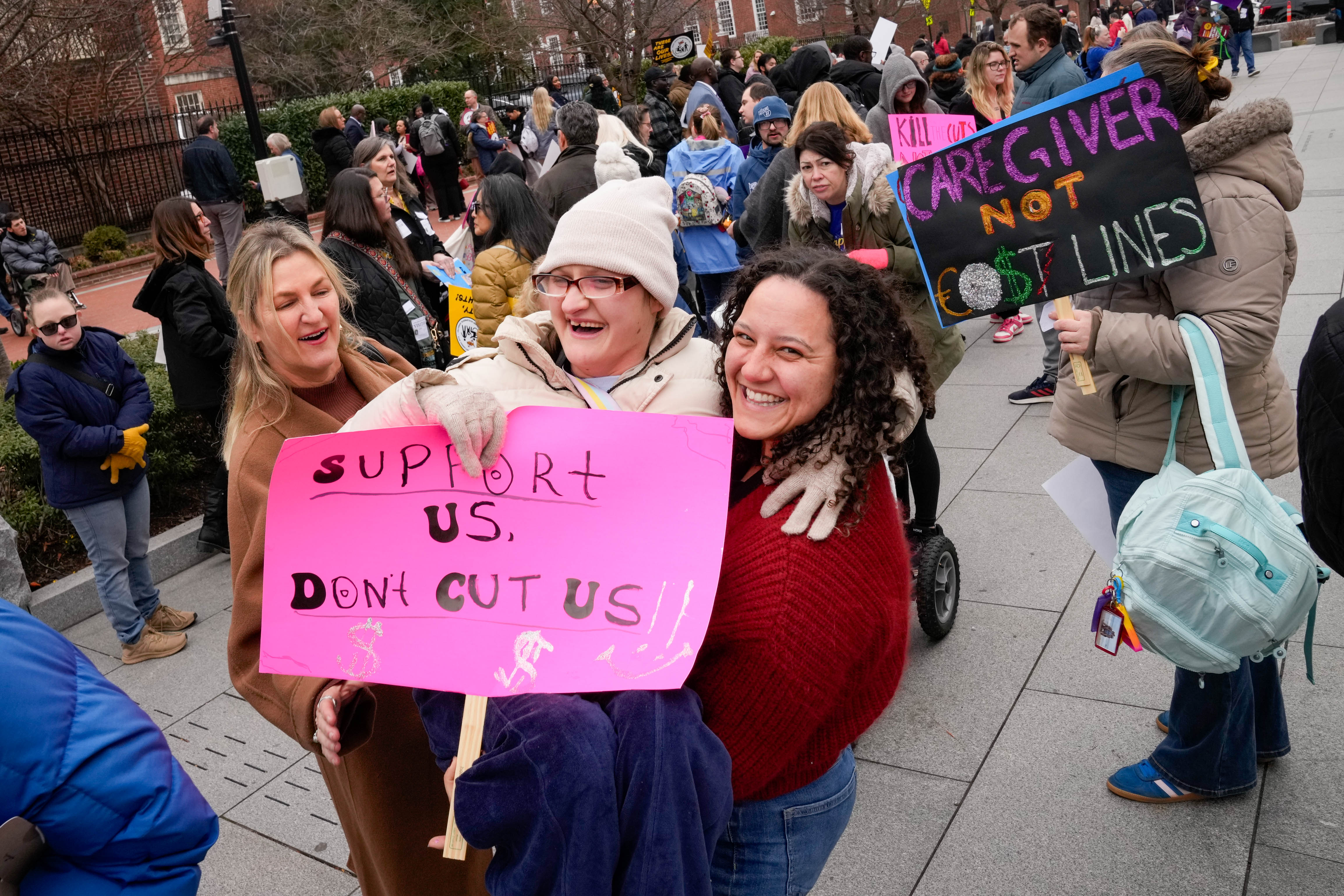 Carin Smith, left, laughs as her daughter, Ellie Smith, is lifted up by Emma Fiore following a rally against budget cuts last week.