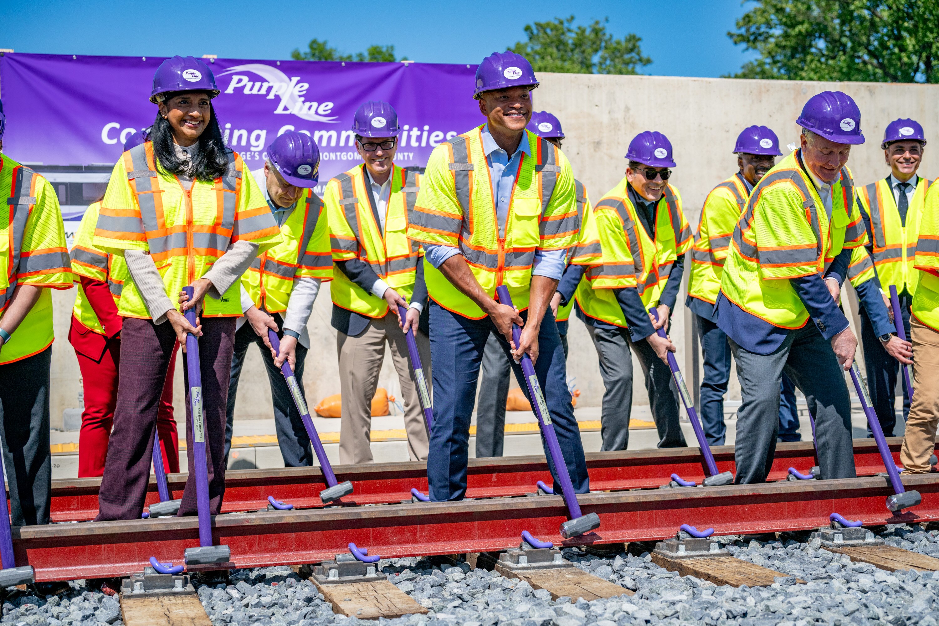 State and local officials, including Lt. Gov. Aruna Miller, Gov. Wes Moore and Sen. Chris Van Hollen, participate in a ceremony marking the installation of the final rail of the Purple Line in Silver Spring earlier this year.