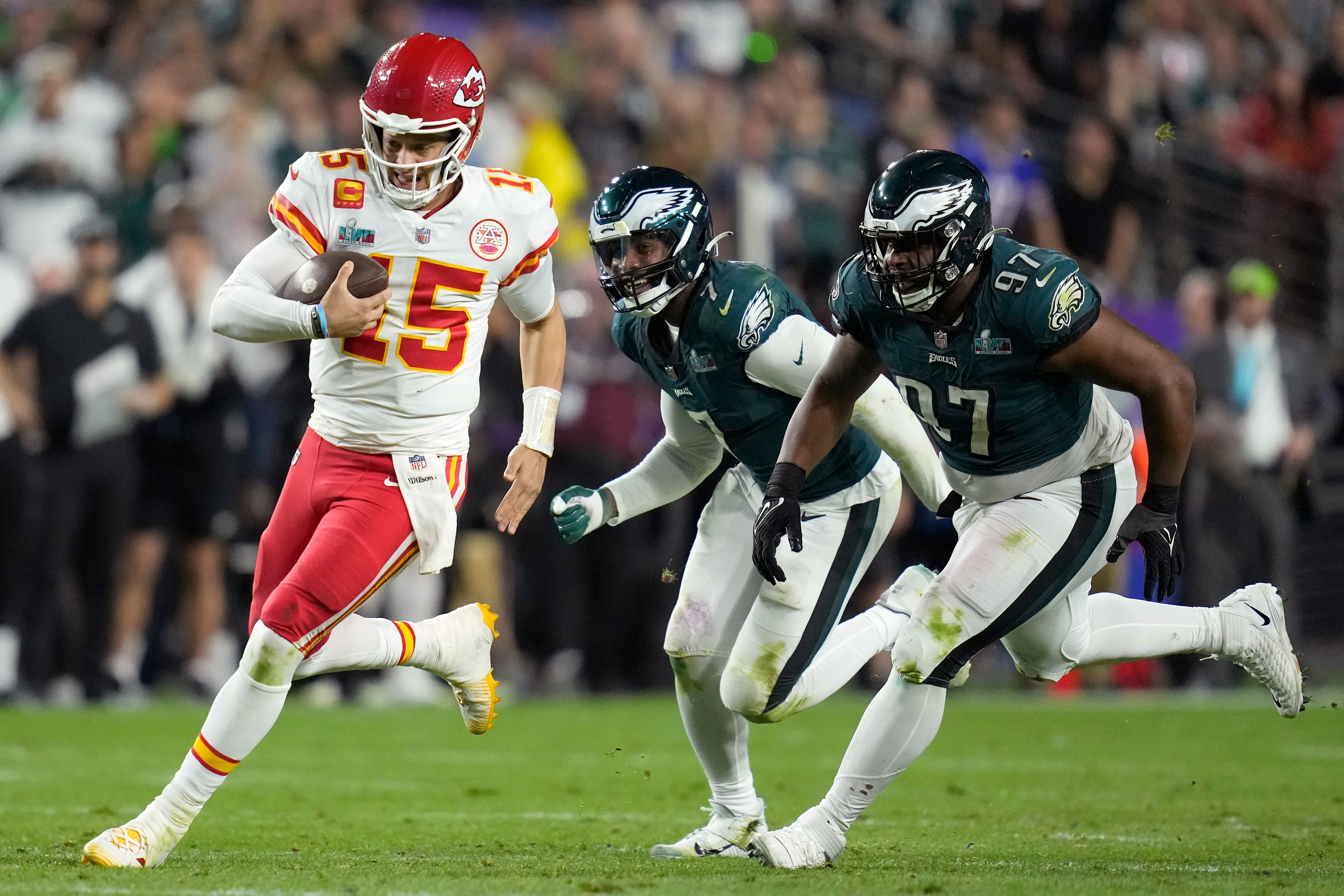 Kansas City Chiefs quarterback Patrick Mahomes (15) runs against Philadelphia Eagles defensive tackle Javon Hargrave (97) and linebacker Haason Reddick (7) during the second half of the NFL Super Bowl 57 football game, Sunday, Feb. 12, 2023, in Glendale, Ariz. (AP Photo/Ashley Landis)