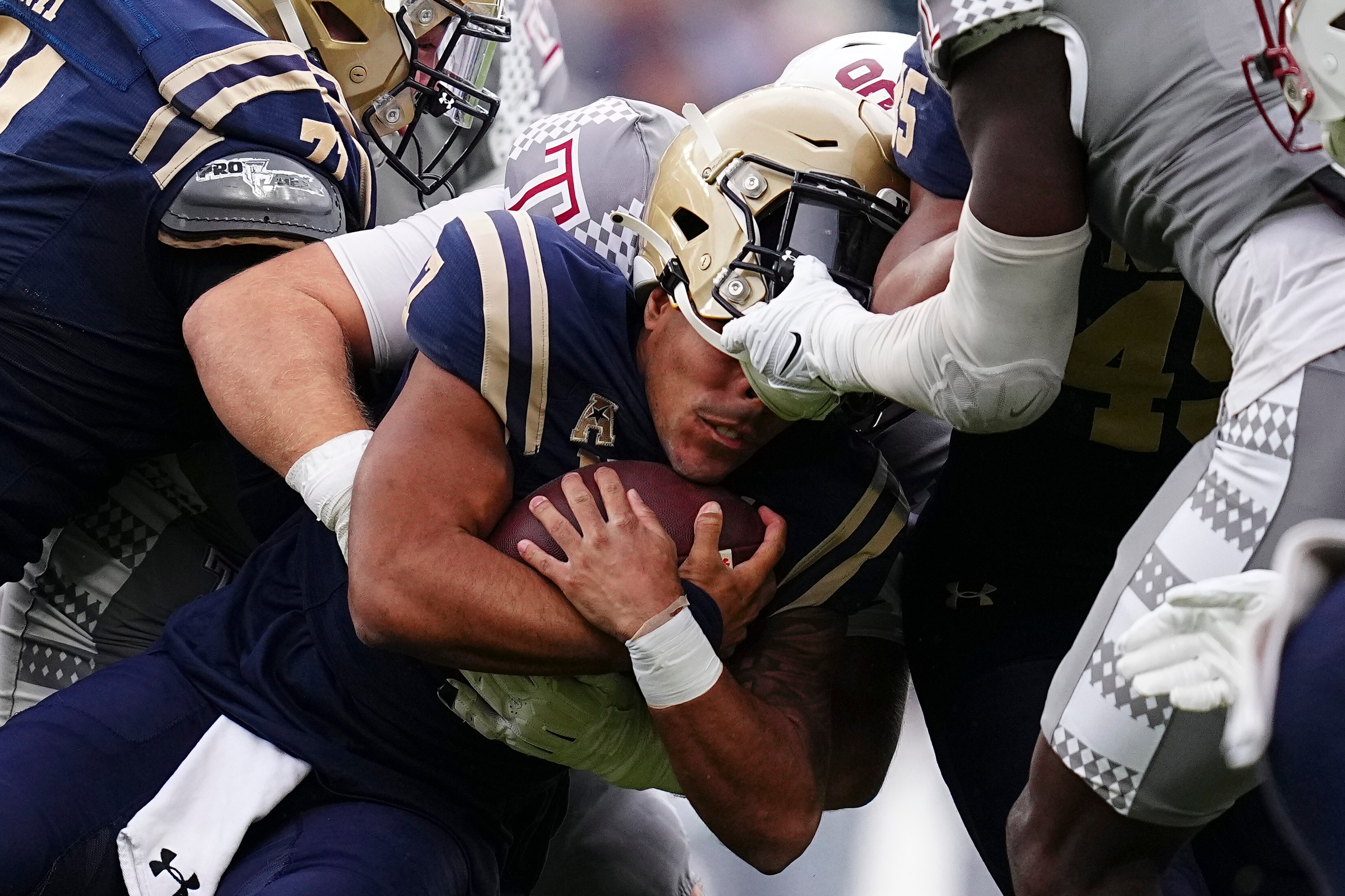 Xavier Arline of Navy has his helmet removed on a first-half tackle.