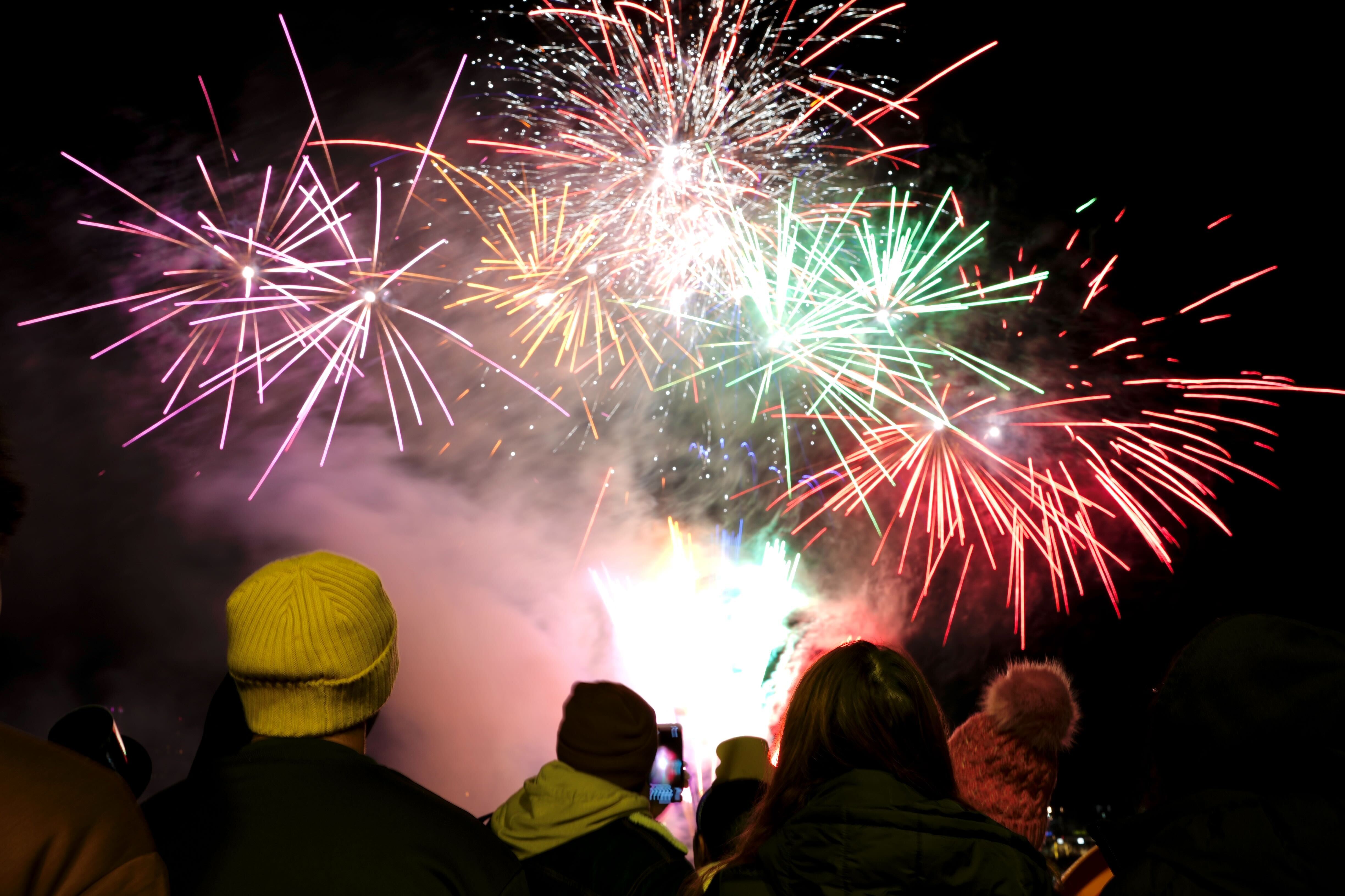 People enjoy the fireworks show by the Inner Harbor to ring in the new year in Baltimore on January 1, 2025.