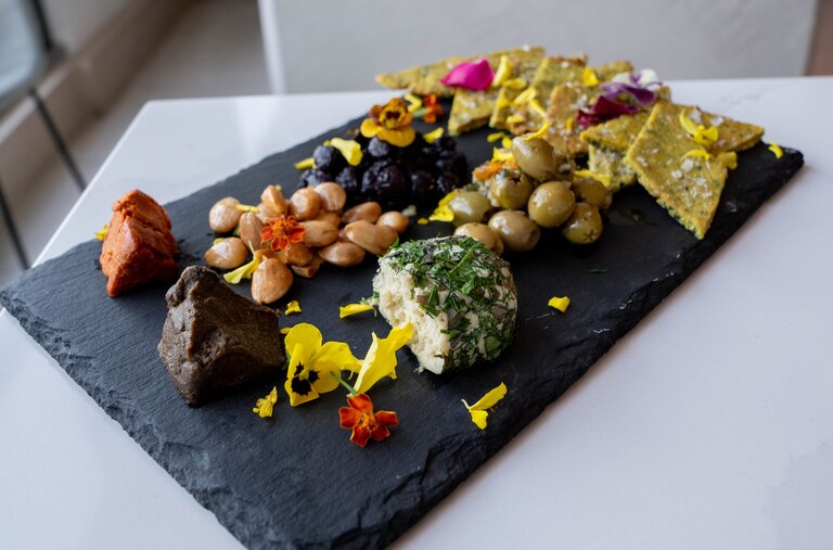 Artisanal Cheese Plate featuring pickles, jam and seedy crackers at Liora.