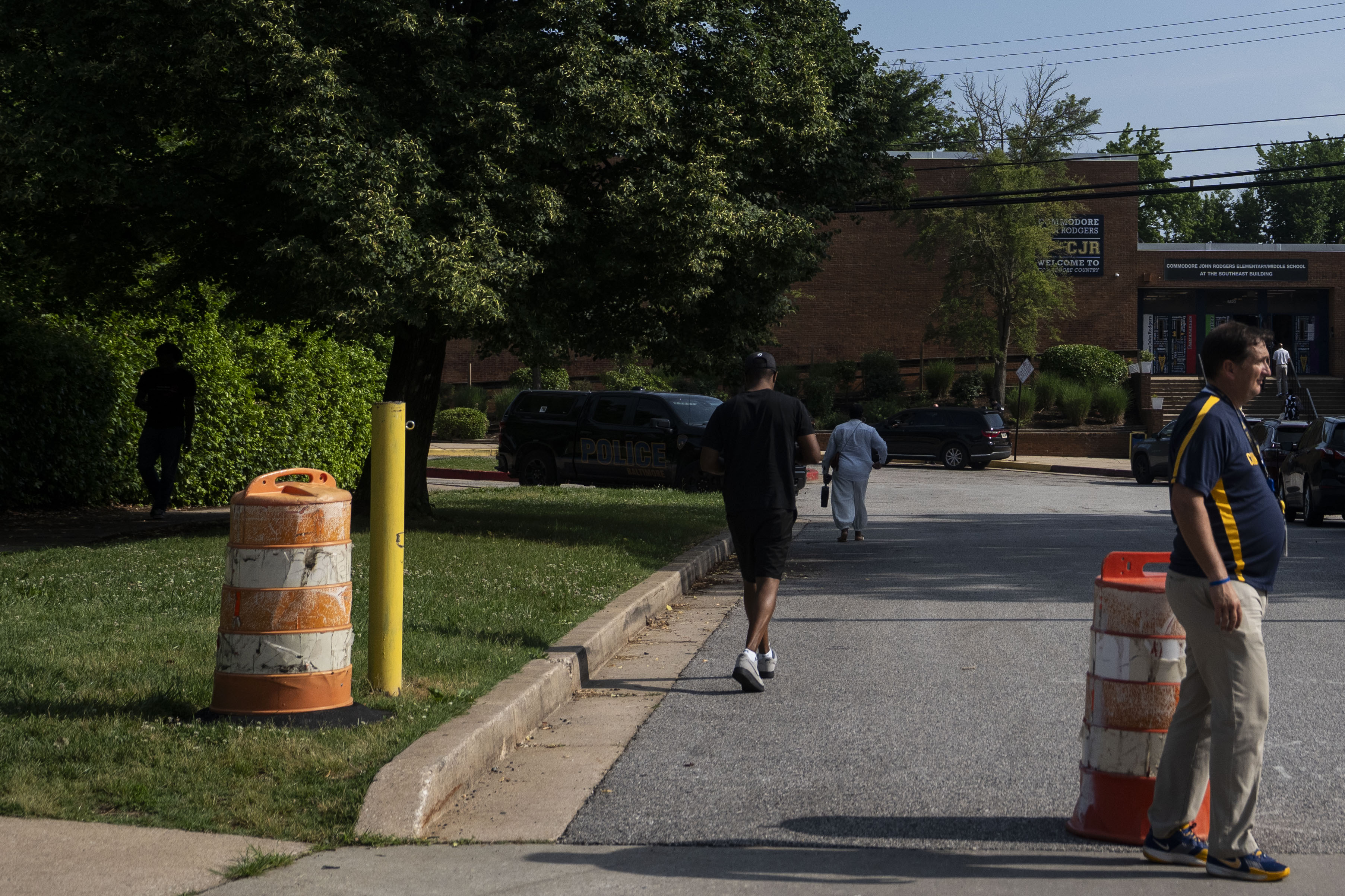 Police vehicles were parked outside Commodore John Rodgers Elementary/Middle School after ICE agents detained two people during school drop-off on Thursday.
