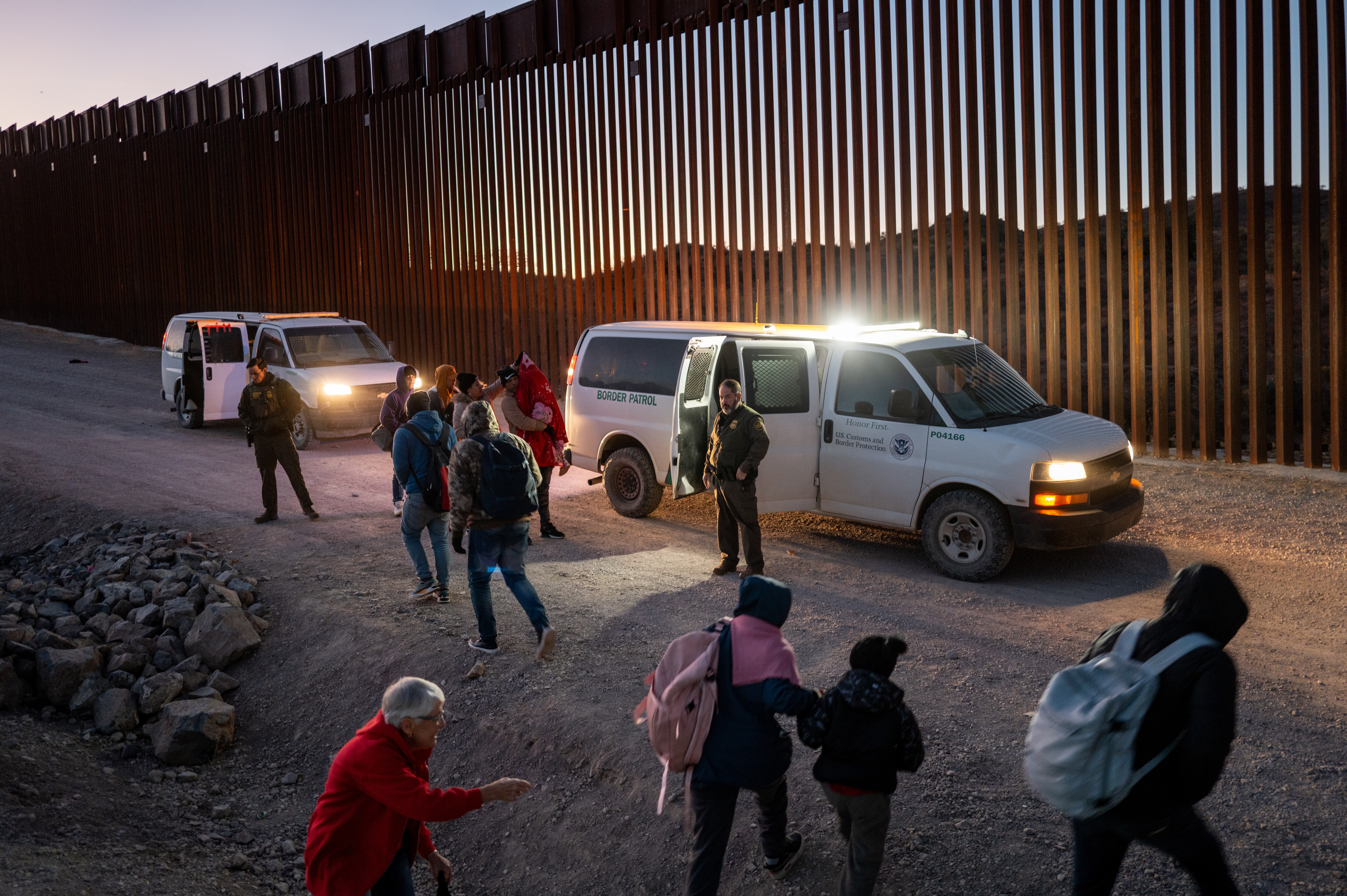 RUBY, ARIZONA - JANUARY 05: Migrants turn themselves in to U.S. Customs and Border Patrol officers after crossing over a section of border wall into the U.S. on January 05, 2025 in Ruby, Arizona. Unlawful border crossings along the Texas Southern border have plummeted to a four-year low according to recent data provided by U.S. Customs and Border Protection. Immigration experts have attributed parts of the decrease to a ruling under the Biden administration which encouraged traveling migrants to make appointments through an app before turning themselves in at ports of entry. The ruling also established that migrants attempting to cross illegally were ineligibile for asylum. President-elect Donald Trump continues speaking about his plans for hardline border and migration policies at the U.S.-Mexico border upon his return to office on January 20.