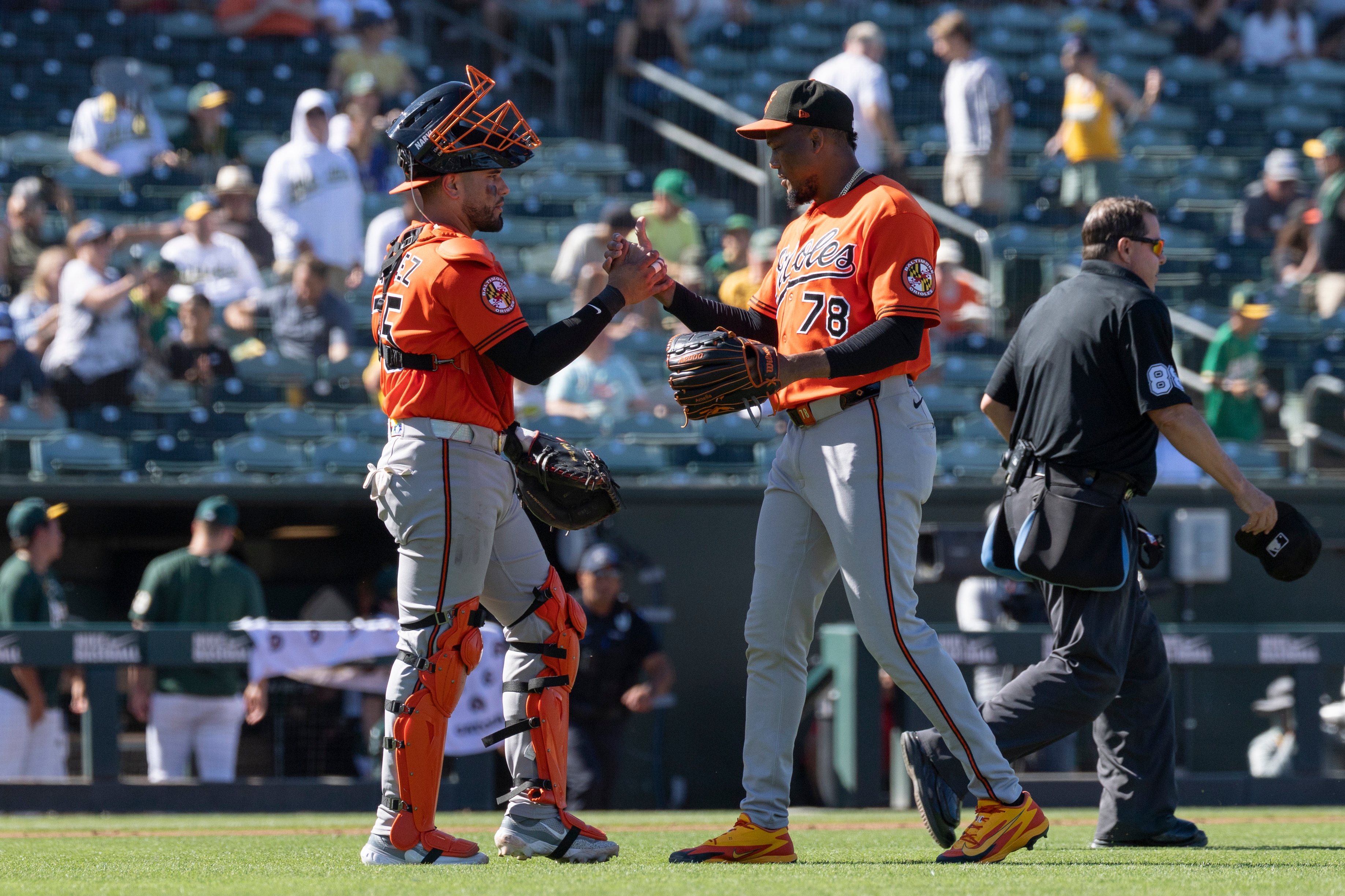 Orioles pitcher Yennier Cano (78) shakes hands with catcher Carlos Narváez, left, after Sunday's win over the Athletics.
