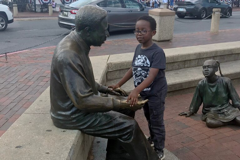 Photo of a child with the Alex Haley statue in Annapolis.