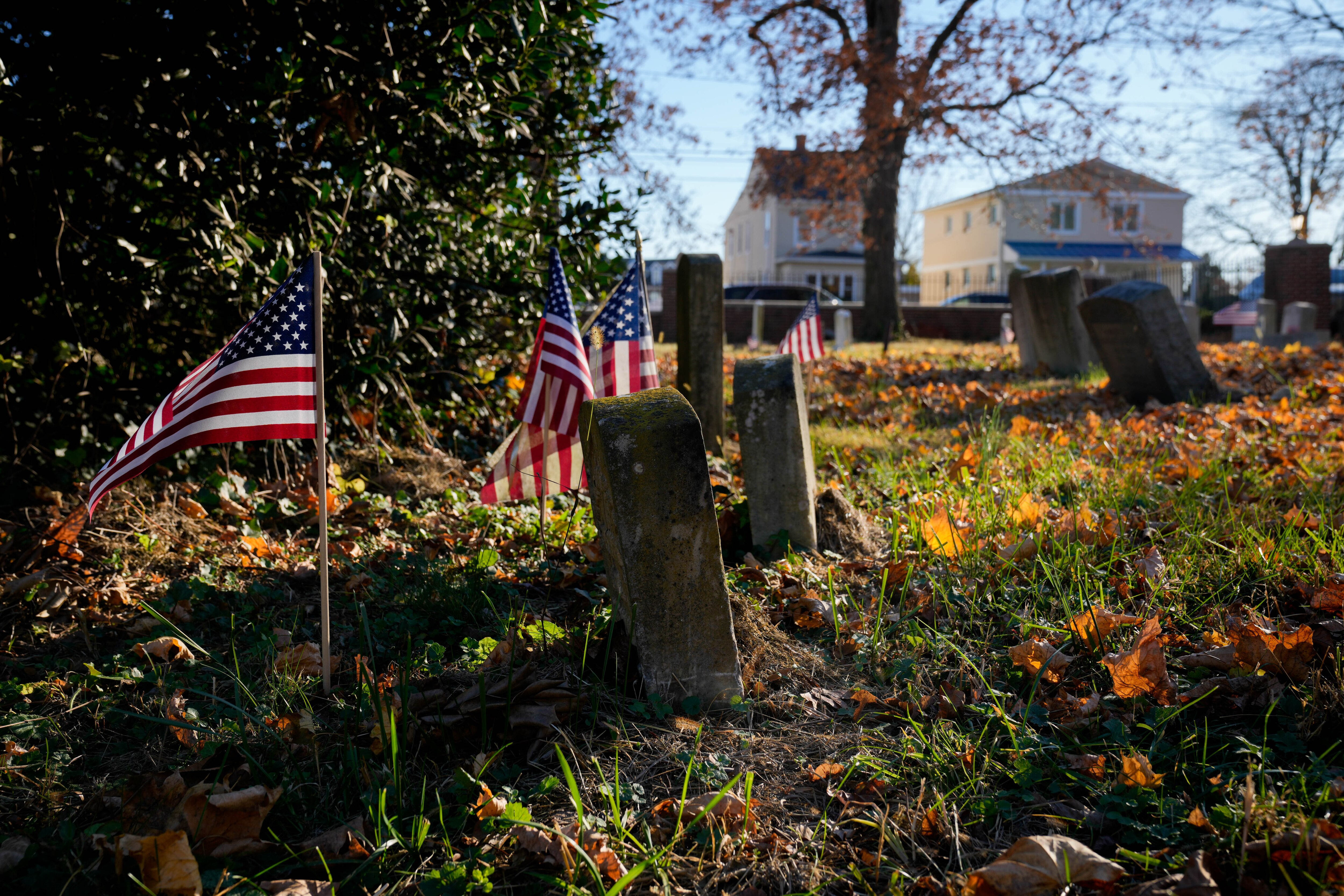 Flags planted near gravestones at Brewer Hill Cemetery in Annapolis.
